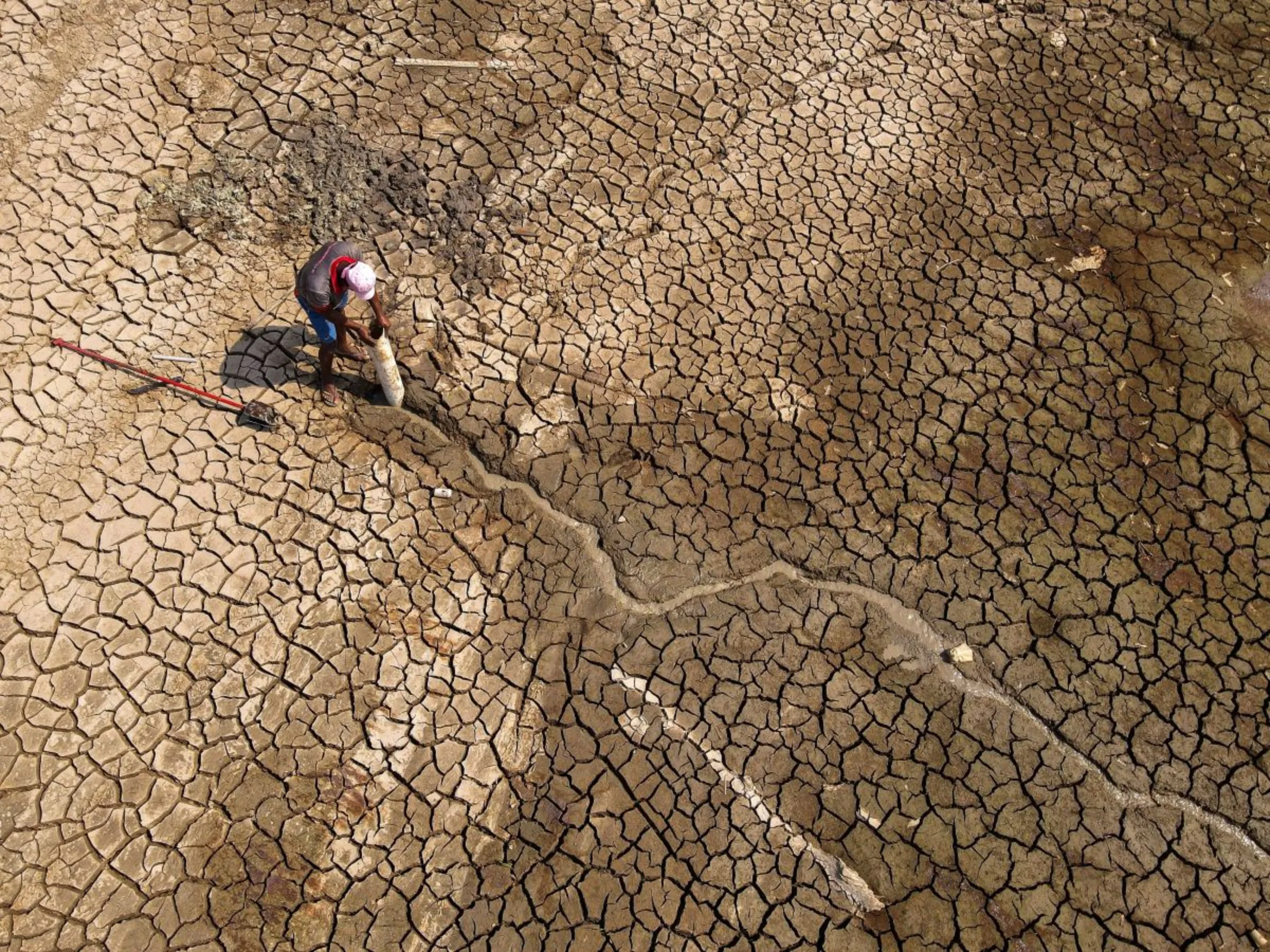 A man searches for water on Puraquequara Lake, which has been affected by historic drought in the Amazon, in Manaus Brazil, October 6, 2023