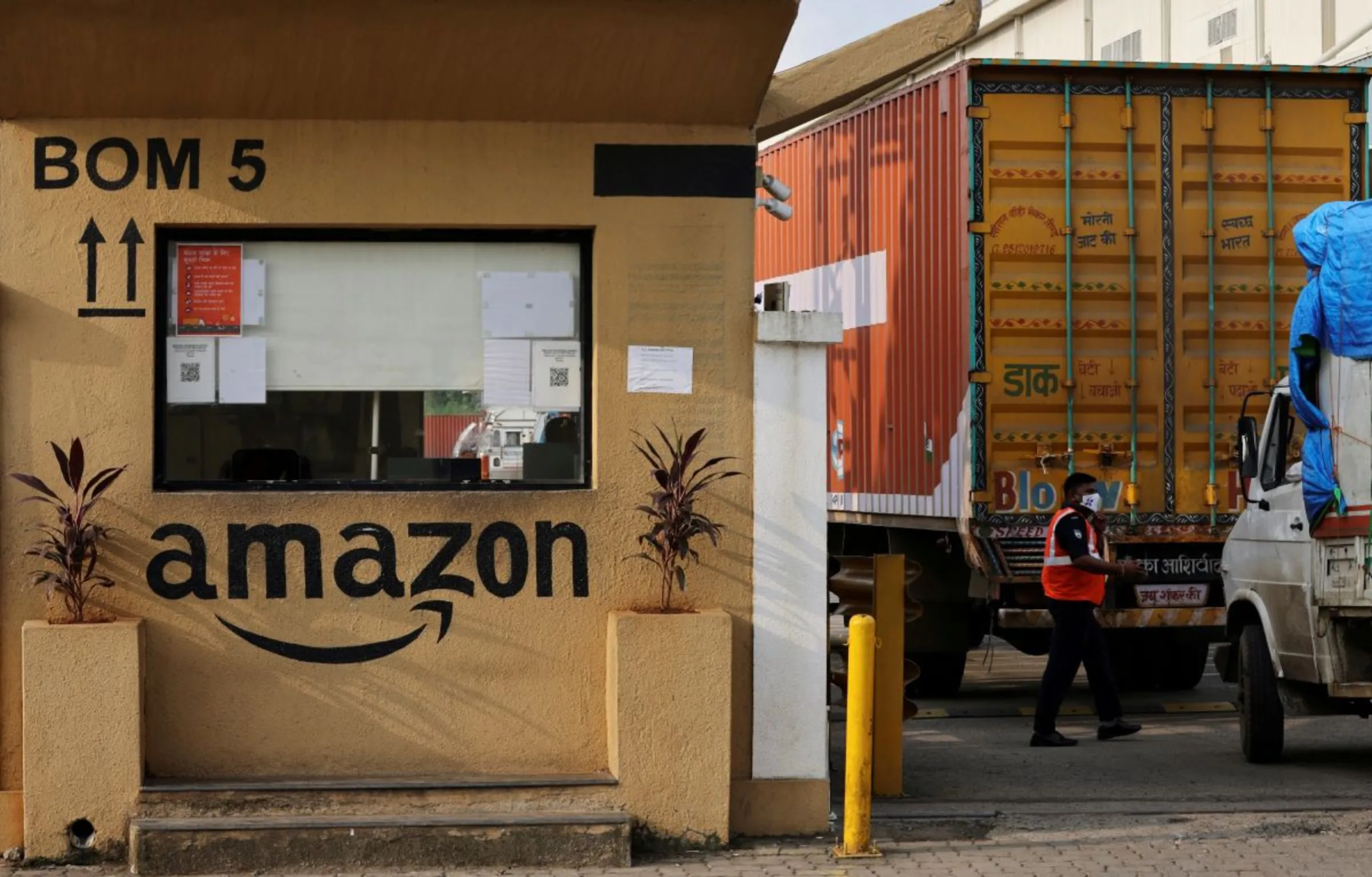 A man inspects trucks before they enter an Amazon storage facility on the outskirts of Mumbai, India, October 1, 2021. Picture taken October 1, 2021. REUTERS/Francis Mascarenhas