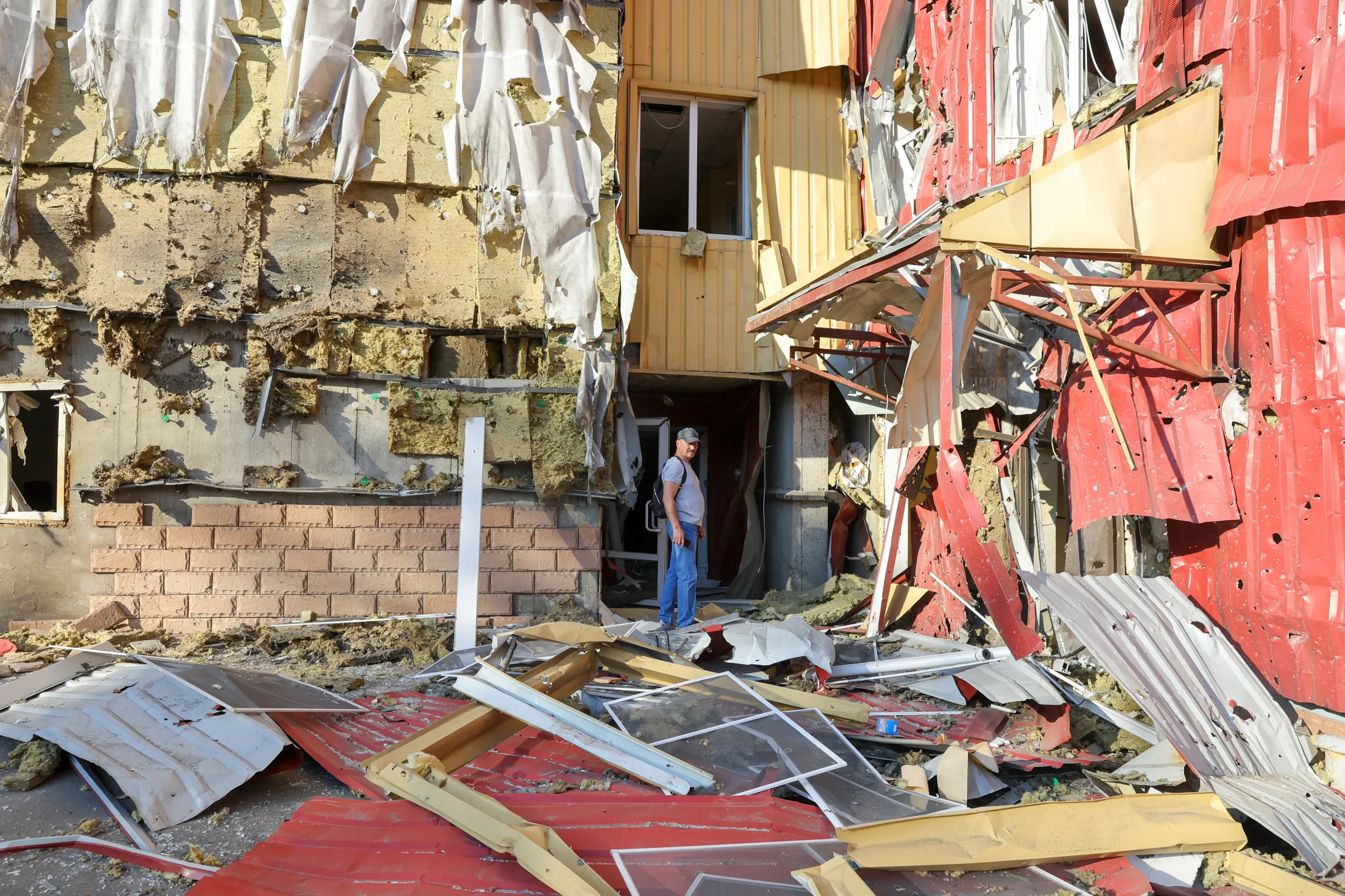 A man stands outside a damaged residential building located in Panfilova street following recent shelling in the course of Ukraine-Russia conflict