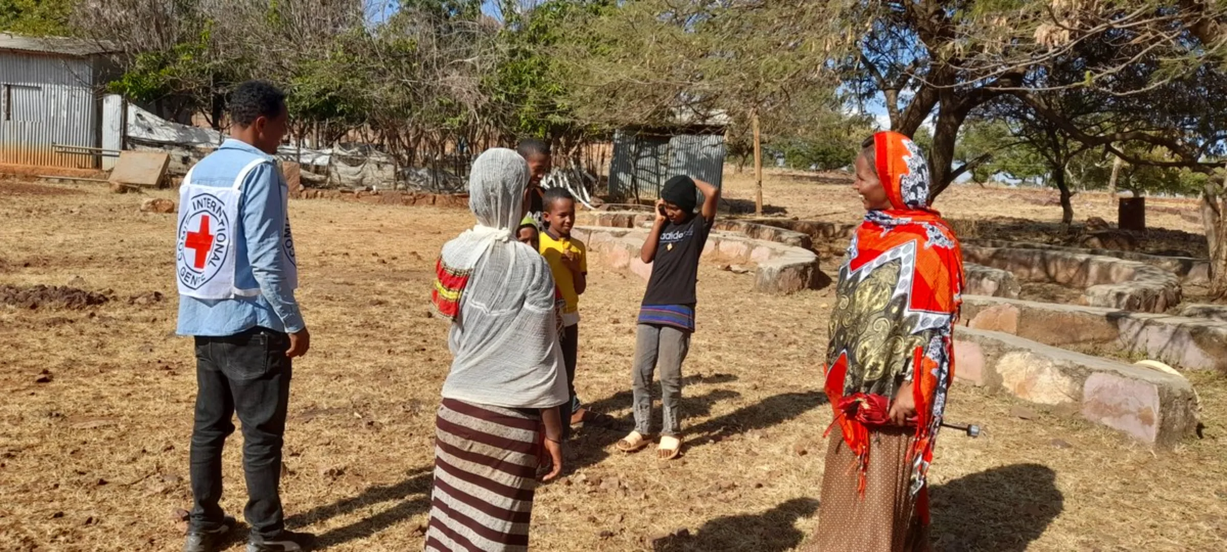 A staff member of the International Red Cross (ICRC) watches as a resident speaks to family on a satellite phone in Tigray, Ethiopia. International Committee of the Red Cross/Handout via Thomson Reuters Foundation