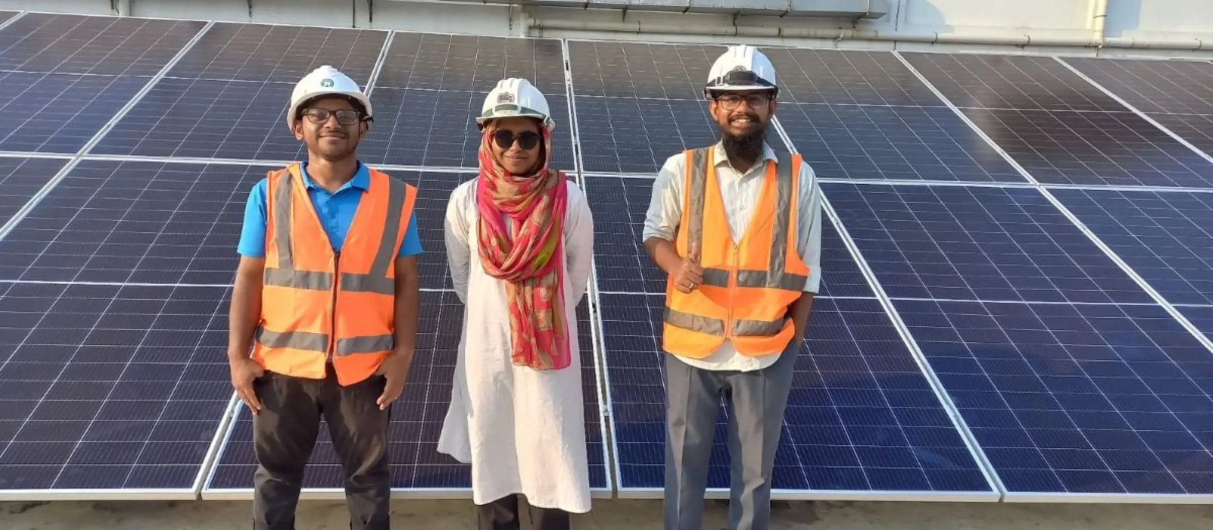 Farzana Akter Isha, a 24-year old engineer, poses before a rooftop solar plant along with her colleagues from SOLshare, Dhaka, Bangladesh, January 2024. Farzana Akter Isha/Handout via Thomson Reuters Foundation