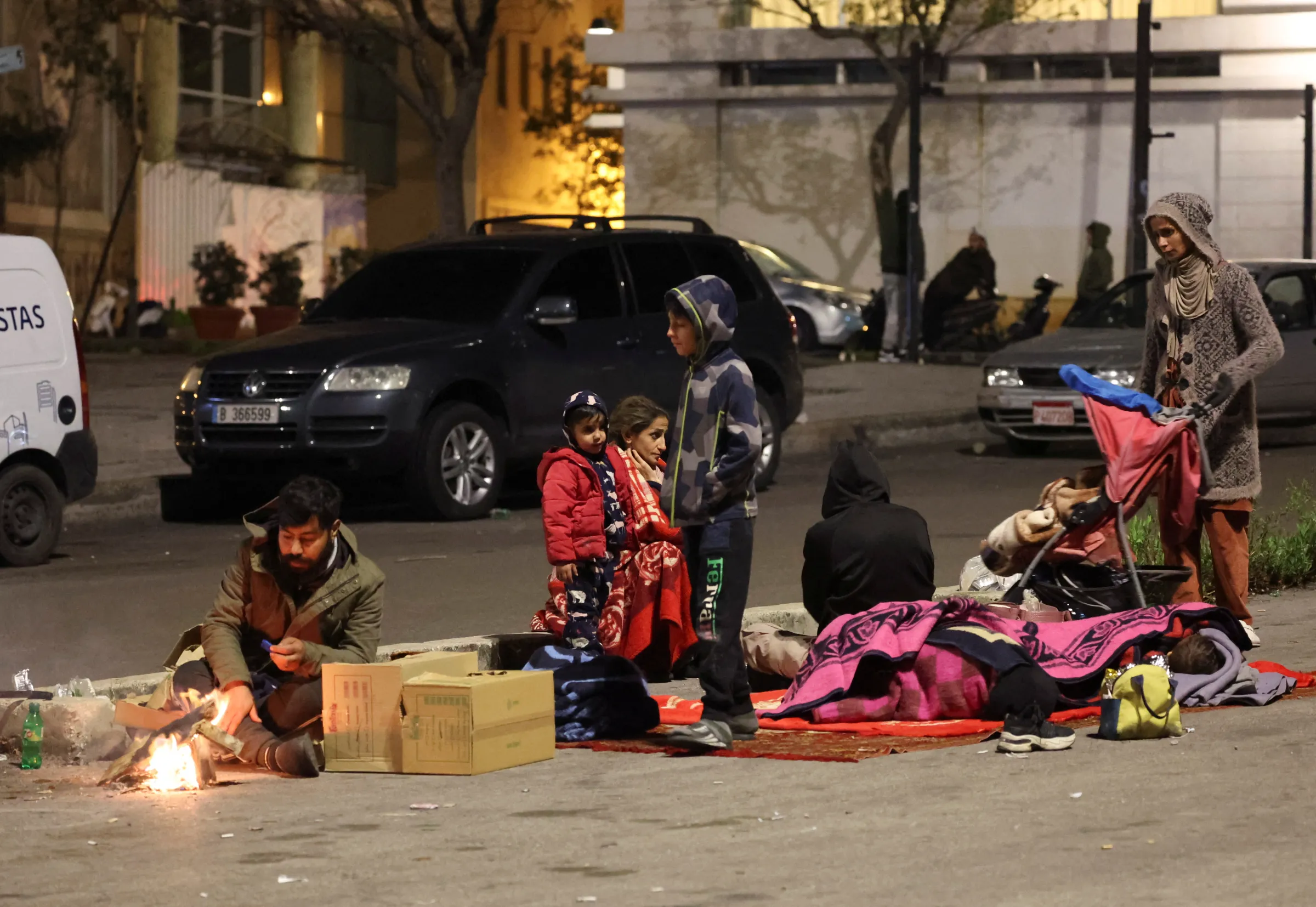 Displaced people who left their homes after Israeli evacuation orders sit along a road in Beirut, Lebanon, November 26, 2024. REUTERS/Mohamed Azakir