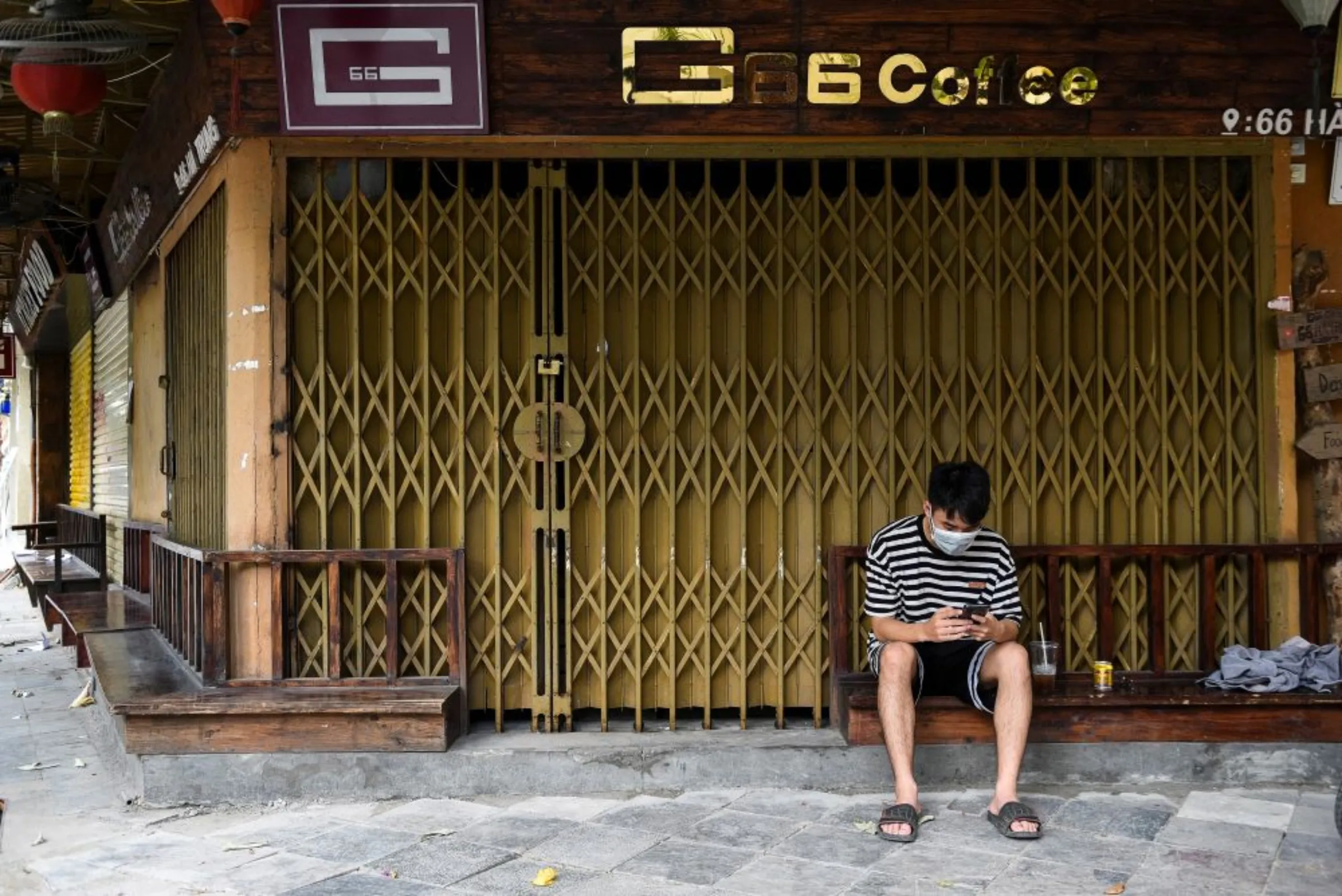 A man sits outside a closed coffee shop amid the coronavirus disease (COVID-19) outbreak in Hanoi, Vietnam, May 31, 2021. REUTERS/Thanh Hue