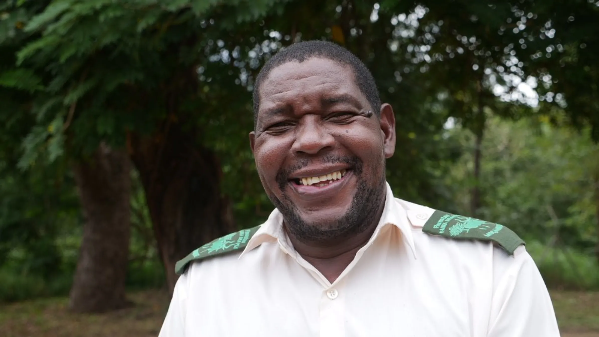 Park warden Pedro Muagura stands beneath trees at Gorongosa National Park in Mozambique, May 30, 2022.