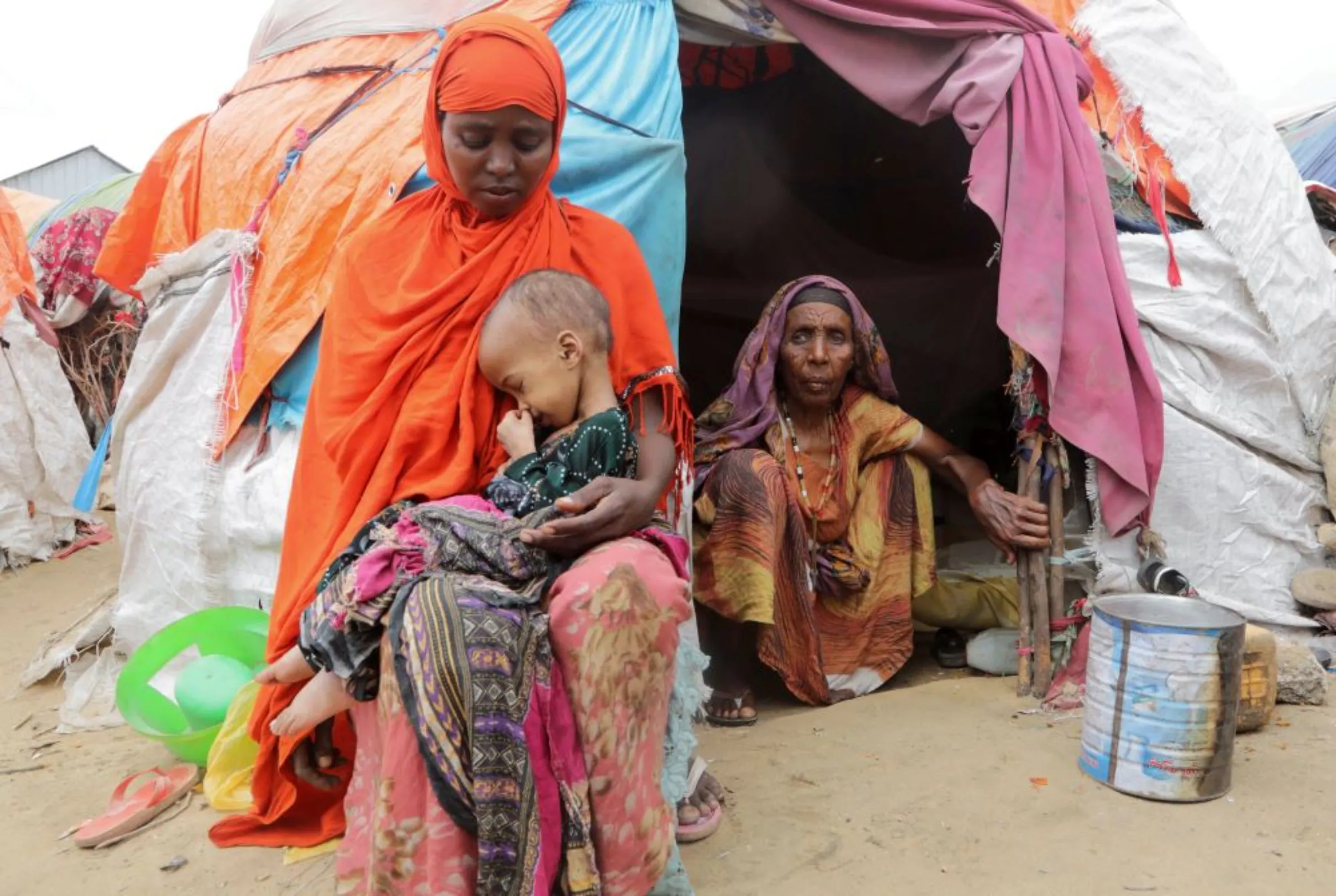 A Somali woman affected by the worsening drought due to failed rain seasons, holds her child, as her grandmother Habiba Osman looks on, outside their makeshift shelter at the Alla Futo camp for internally displaced people, in the outskirts of Mogadishu, Somalia September 23, 2022