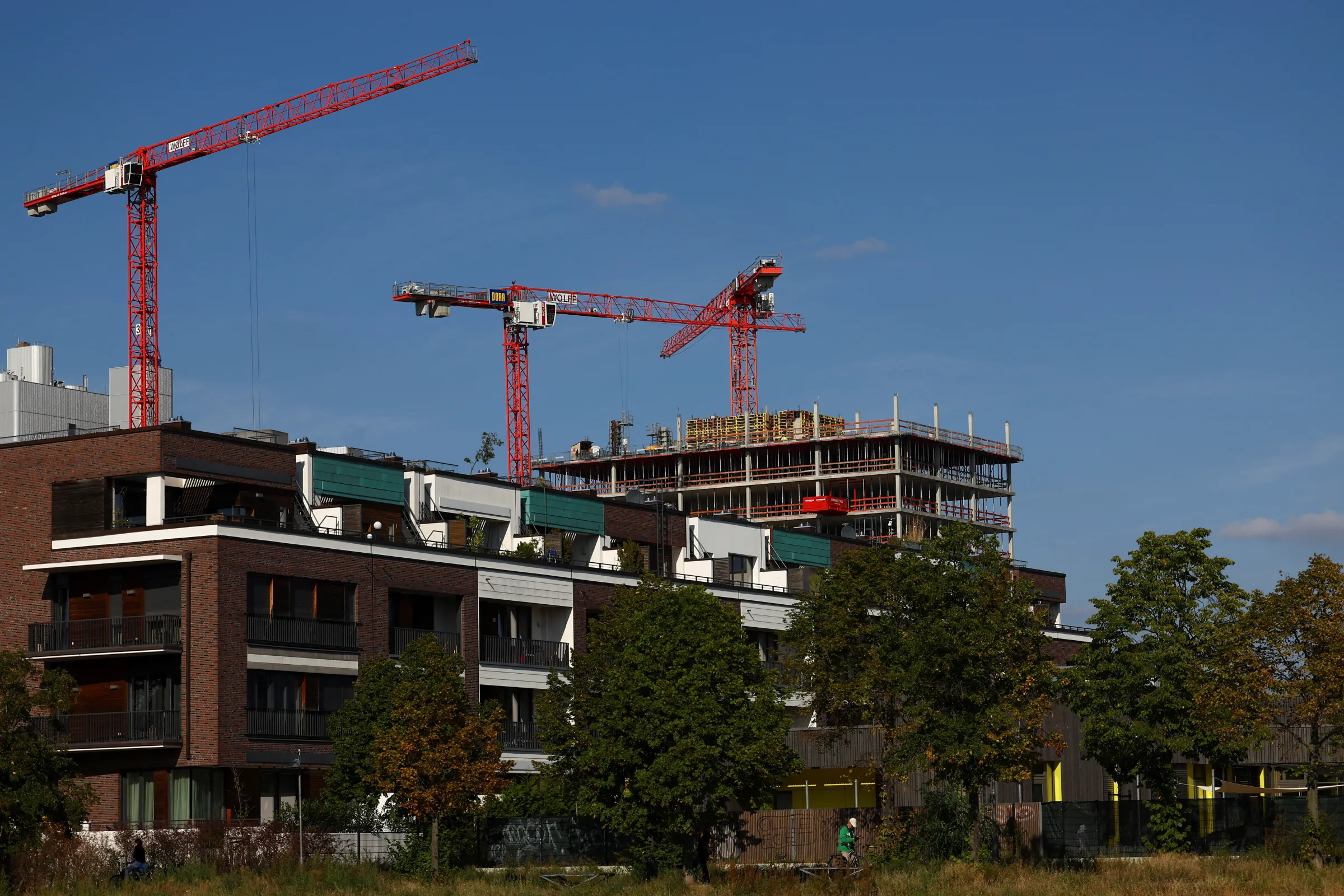 Cranes of a construction site are seen near a residential building, ahead of the summit for affordable housing and construction at the Chancellery in Berlin, Germany September 25, 2023. REUTERS/Lisi Niesner