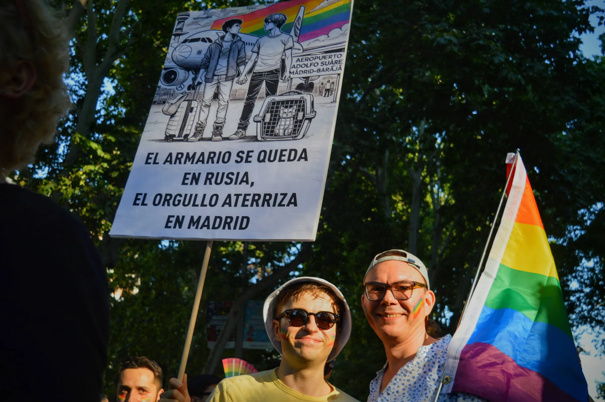 Two Russian men pose at Madrid Pride holding a rainbow flag and a poster that reads “The closet stays in Russia, Pride lands in Madrid”, Madrid, Spain, July 6, 2024. Thomson Reuters Foundation/Laura Valentina Cortés Sierra