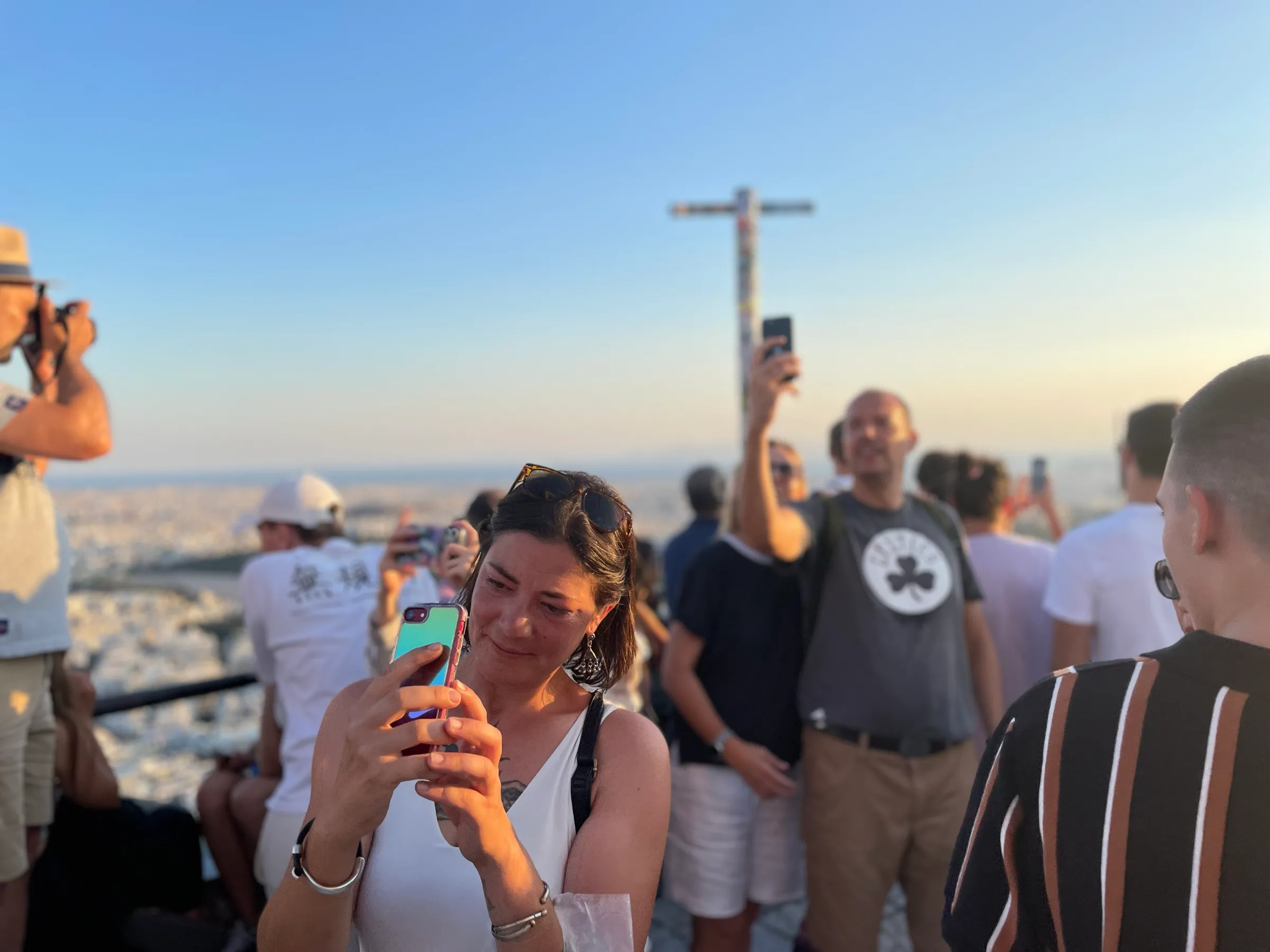Tourists take pictures of the view at sunset from the top of Lycabettus hill, Athens, Greece. July 30, 2024. Thomson Reuters Foundation/Beatrice Tridimas