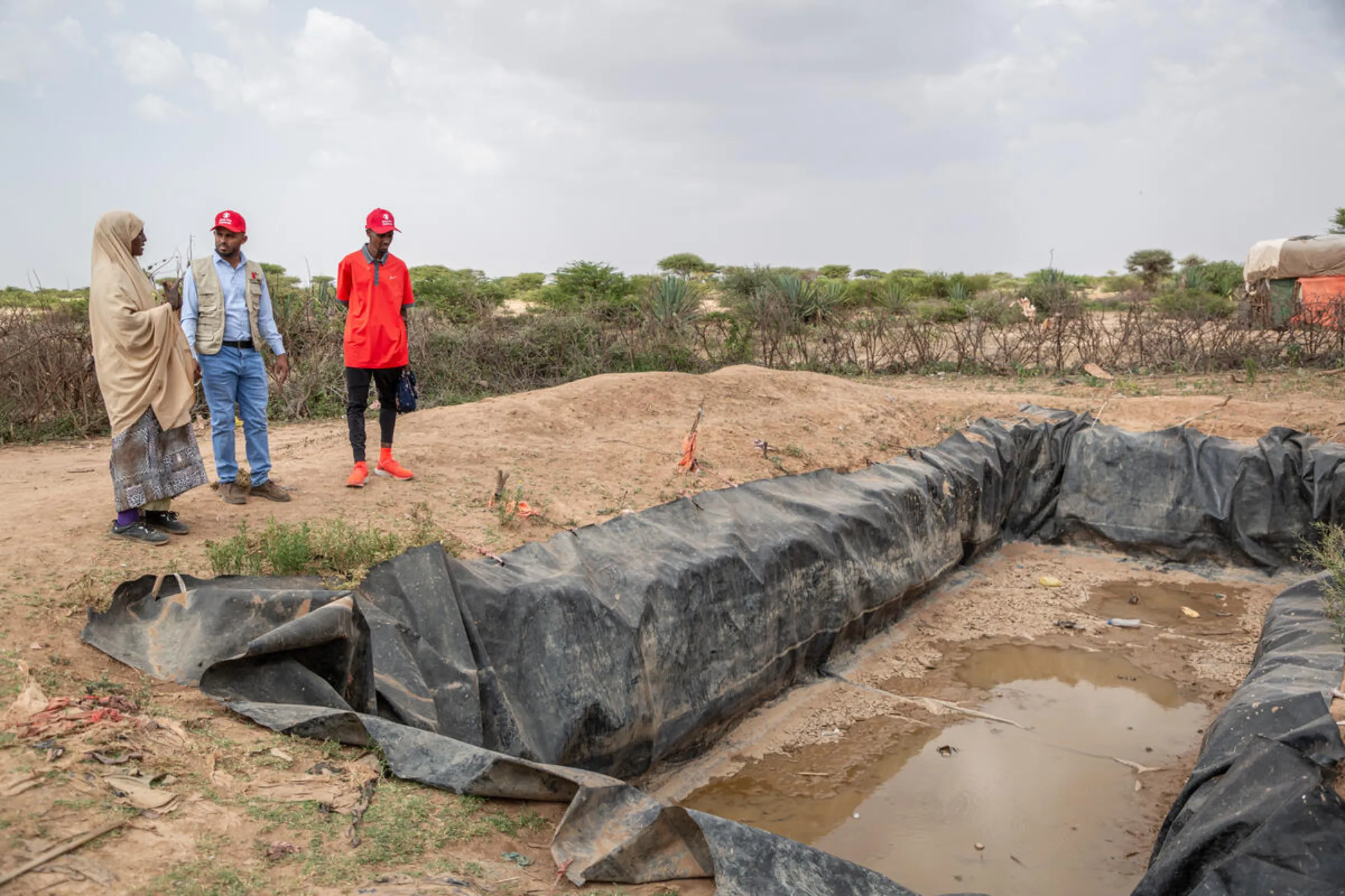 Save the Children health worker Sabaad shows Sir Mo Farah the little water she has left which unsafe to drink in Somaliland, May 28, 2024. Mustafa Saeed/Save the Children/Handout via Thomson Reuters Foundation