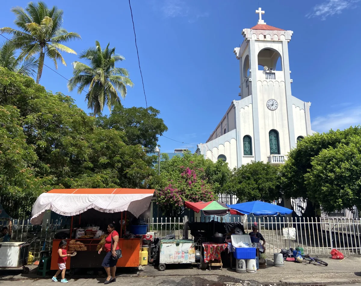 Traders sell their wares from market stalls set up in front of a church in the poor farming community of Nueva Concepción, El Salvador, on Sept 9, 2022. Thomson Reuters Foundation/Anna-Catherine Brigida
