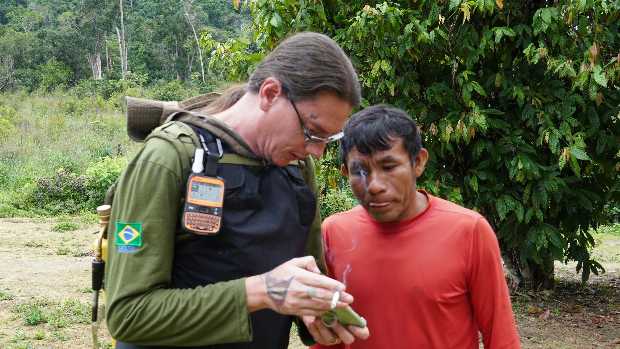 Jefferson Rodrigues, an inspector with the Indigenous affairs agency FUNAI, consults with Clementino Puxu, a Munduruku man, about the location of an illegal mining site, in the village of Curima inside the Munduruku Indigenous Reserve, Brazil, Jan 9, 2025. Thomson Reuters Foundation/Dan Collyns