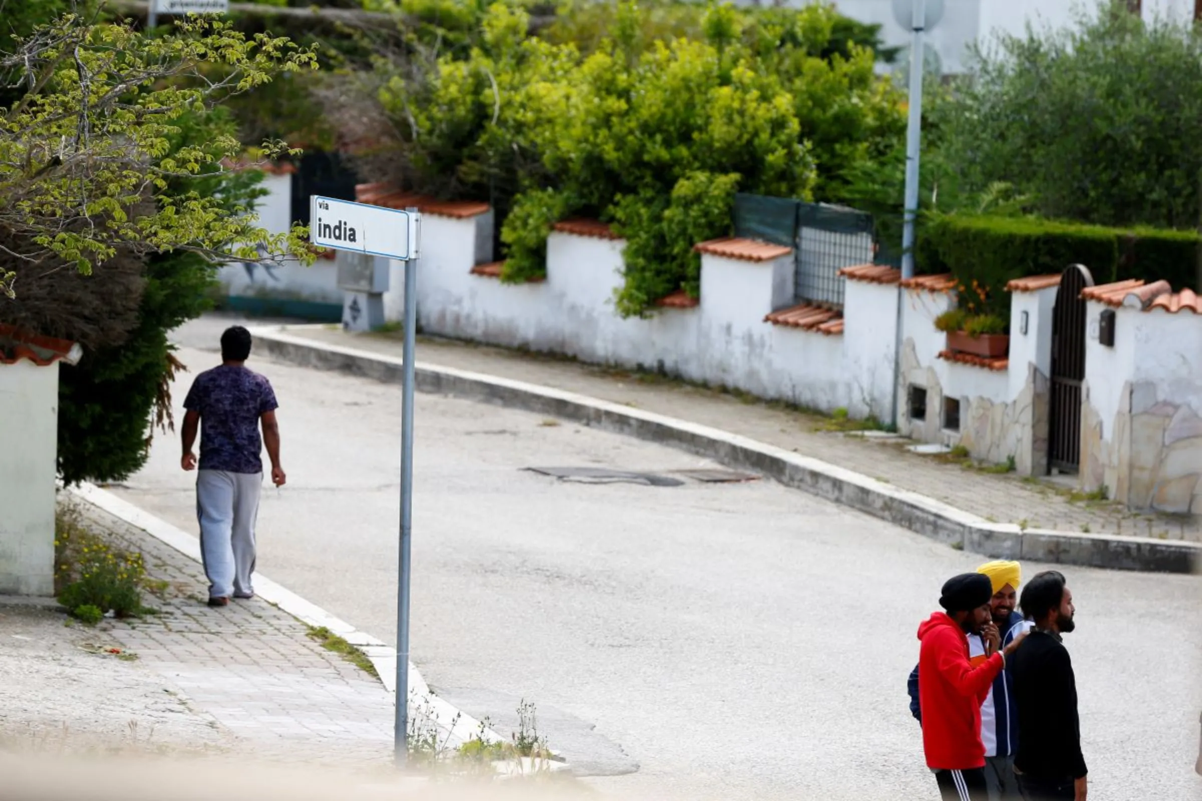 Young Sikh migrant workers walk on a street in the Agro Pontino area, south of Rome. Picture taken May 19, 2019 REUTERS/Yara Nardi