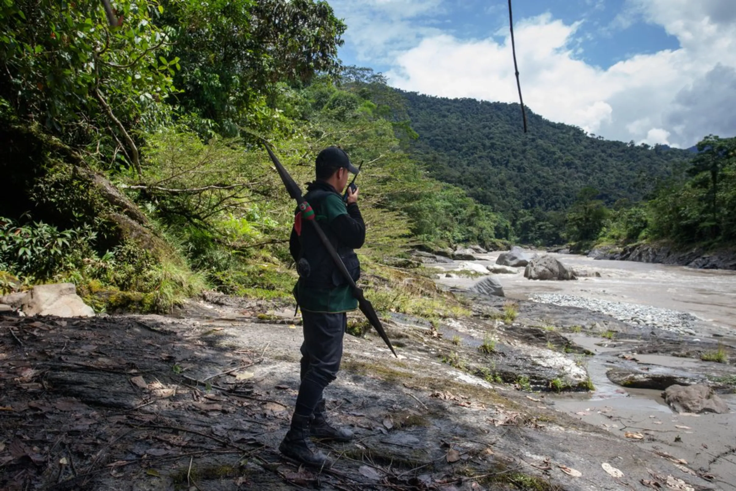 Marcelo Lucitante, a member of the Cofan indigenous guard, speaks on a radio while on patrol on the banks of the Aguarico River in northern Ecuador near their village of Sinangoe, on April 21, 2022