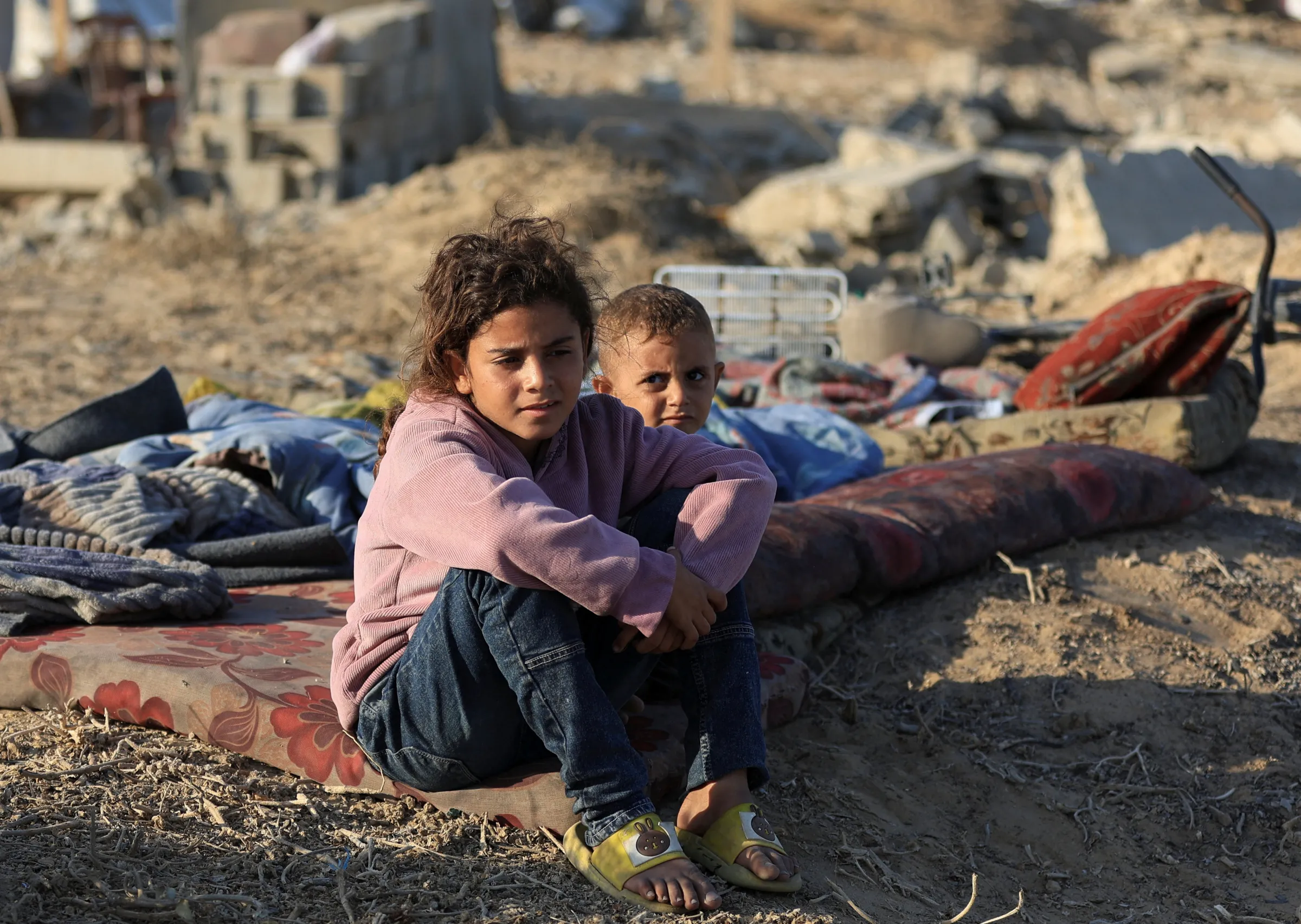 Displaced Palestinian children sit on a mat in the central Gaza Strip, September 26, 2025. REUTERS/Dawoud Abu Alkas