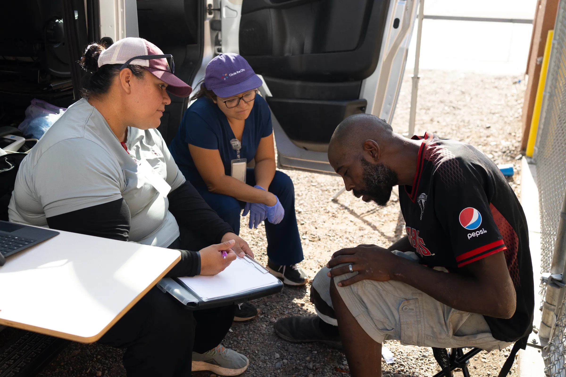 Tyrone James nods off as he is given water, personal hygiene supplies and a dressing for an infected wound. July 15, 2024. Thomson Reuters Foundation/Rebecca Noble