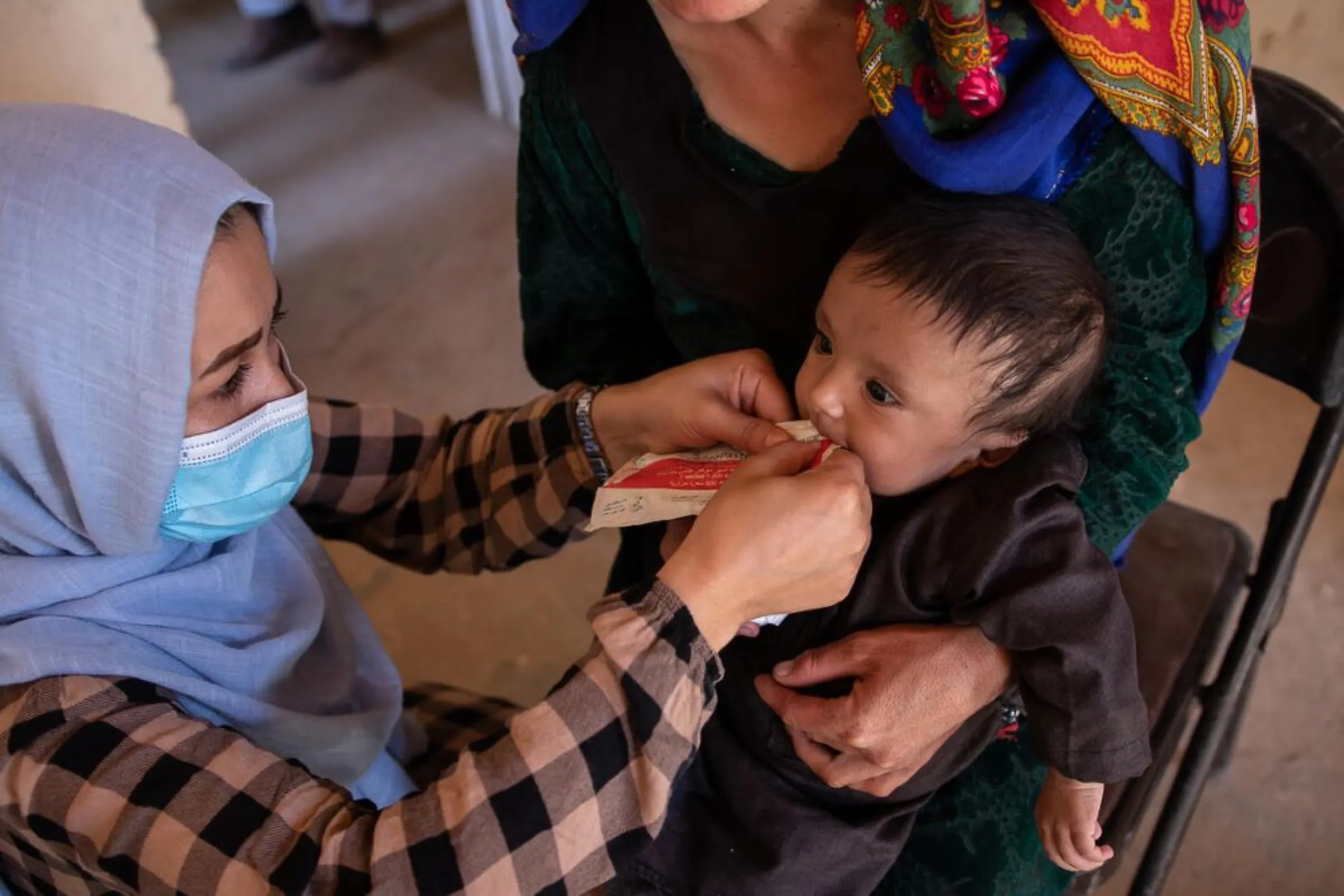A health worker feeds a baby to treat malnutrition in Faryab province, Afghanistan, February 21, 2022