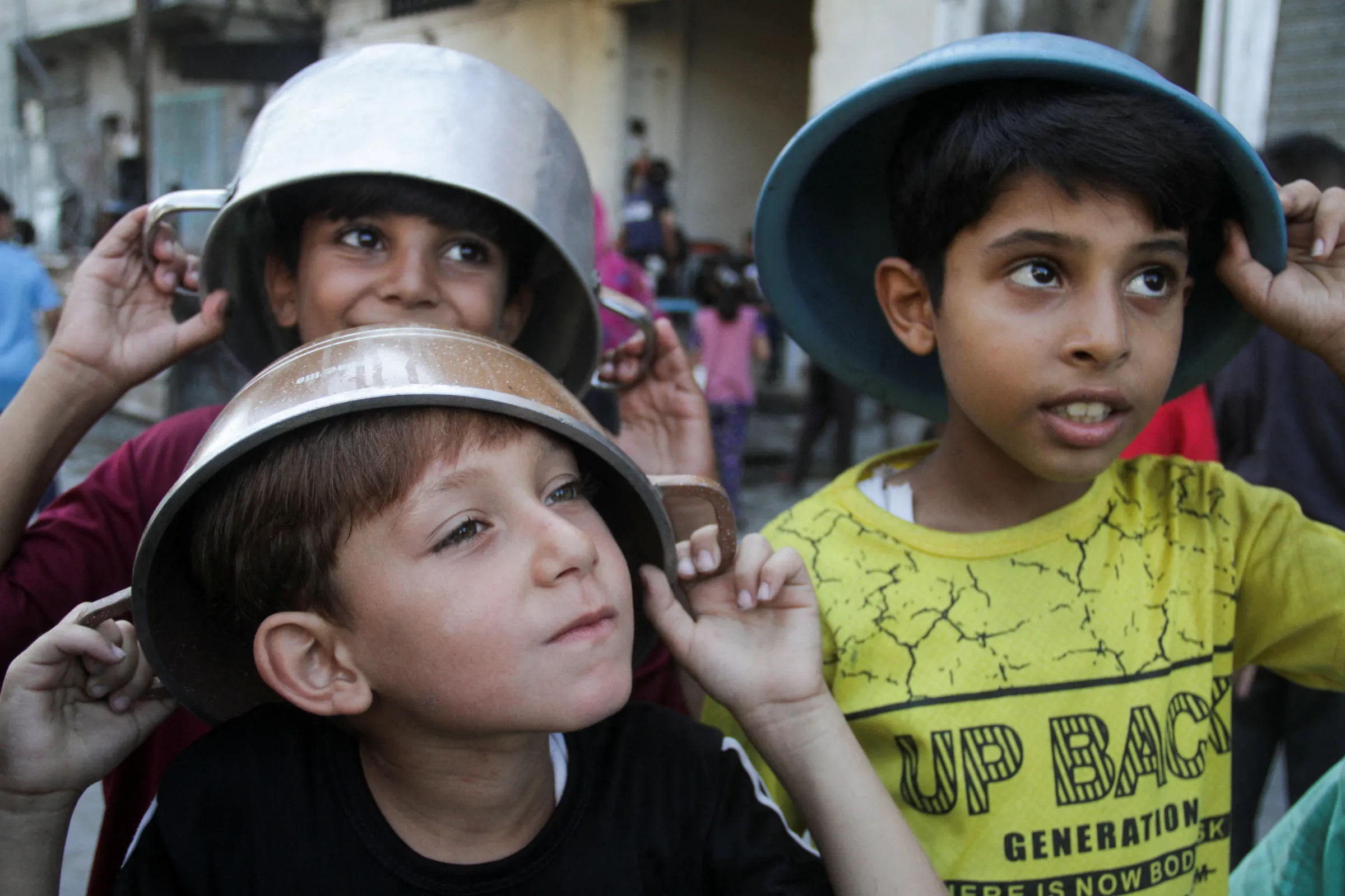 Palestinian children wait to receive food cooked by a charity kitchen, amid a hunger crisis as conflict between Israel and Hamas continues, in the northern Gaza Strip August 14, 2024. REUTERS/Mahmoud Issa