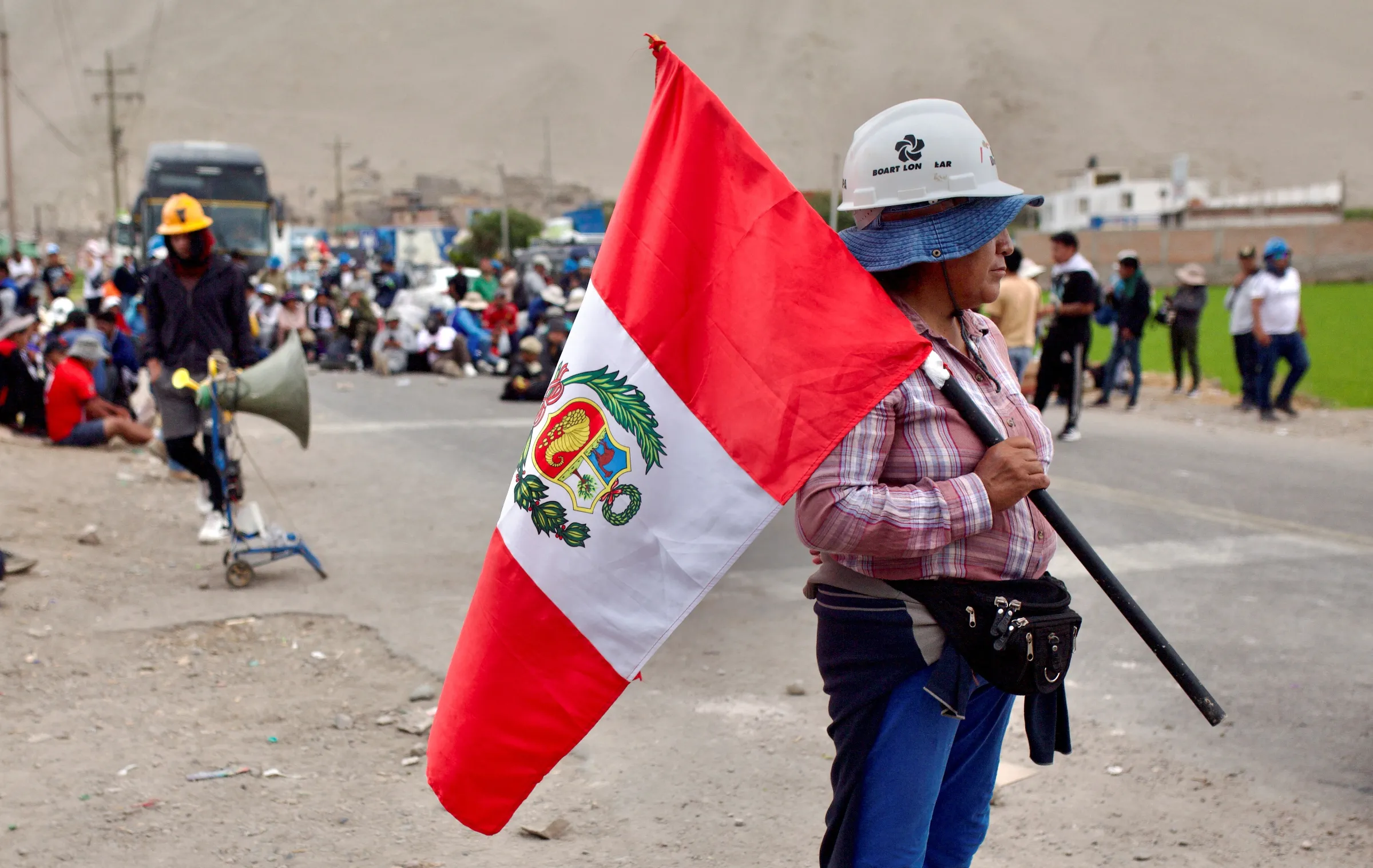 Demonstrator holds Peru's flag during miners' protest demanding the extension of a program that allows them to operate temporarily in Ocona, Peru November 27, 2024. REUTERS/Oswald Charca