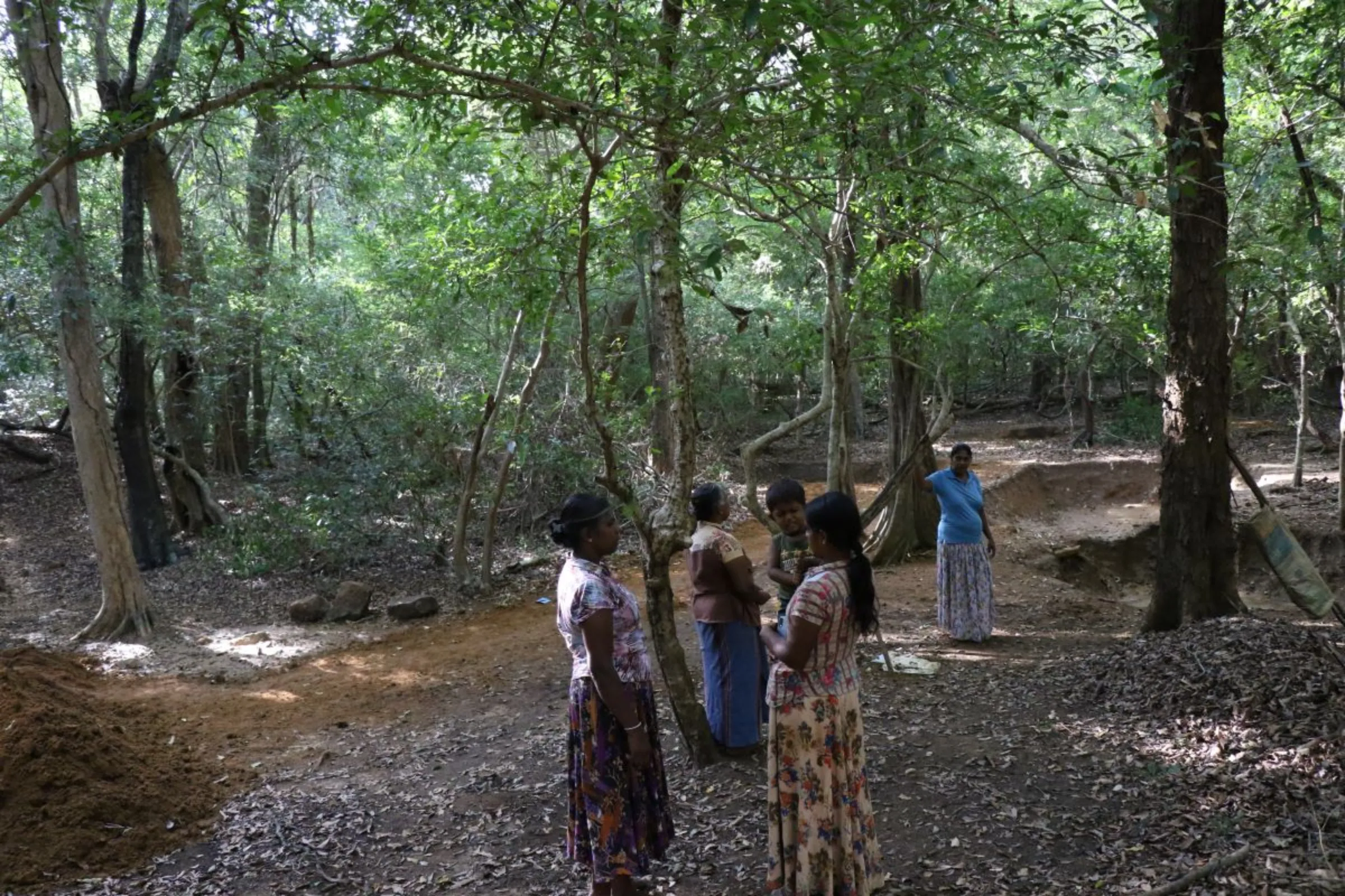 Renuka Karunarathna and other women farmers stand in the forest area near Sapumal Thenna where they want to make a small reservoir. August 2023. Thomson Reuters Foundation/Ranga Udugama