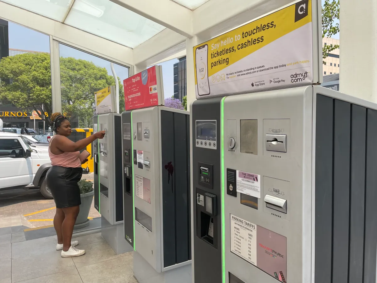 A woman pays for her parking at a pay point in Rosebank Mall in Johannesburg, South Africa, October 7, 2022. Thomson Reuters Foundation/Kim Harrisberg