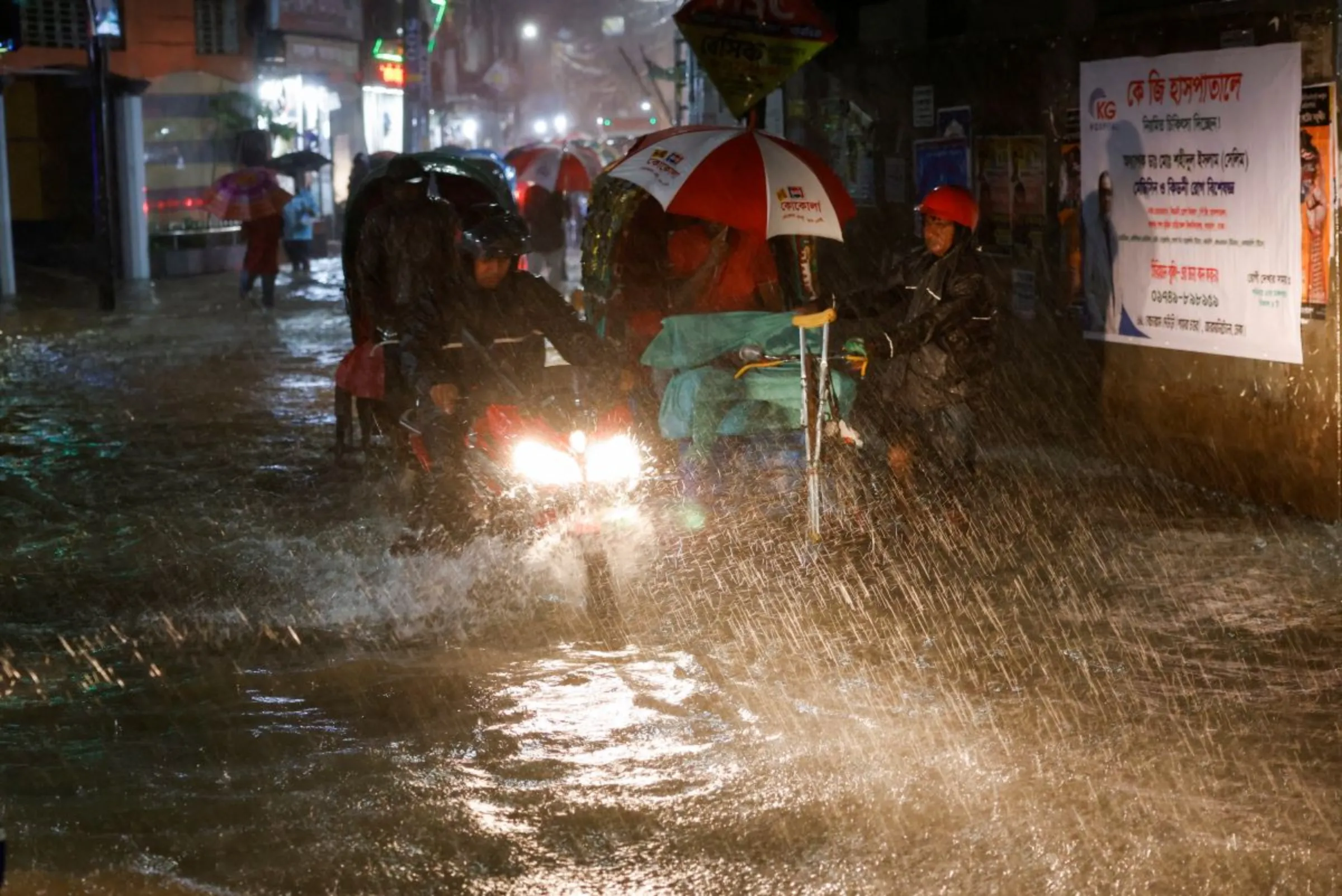 People ride rickshaws and motorcycle on a flooded street, amid continuous rain before the Cyclone Sitrang hits the country in Dhaka, Bangladesh, October 24, 2022. REUTERS/Mohammad Ponir Hossain