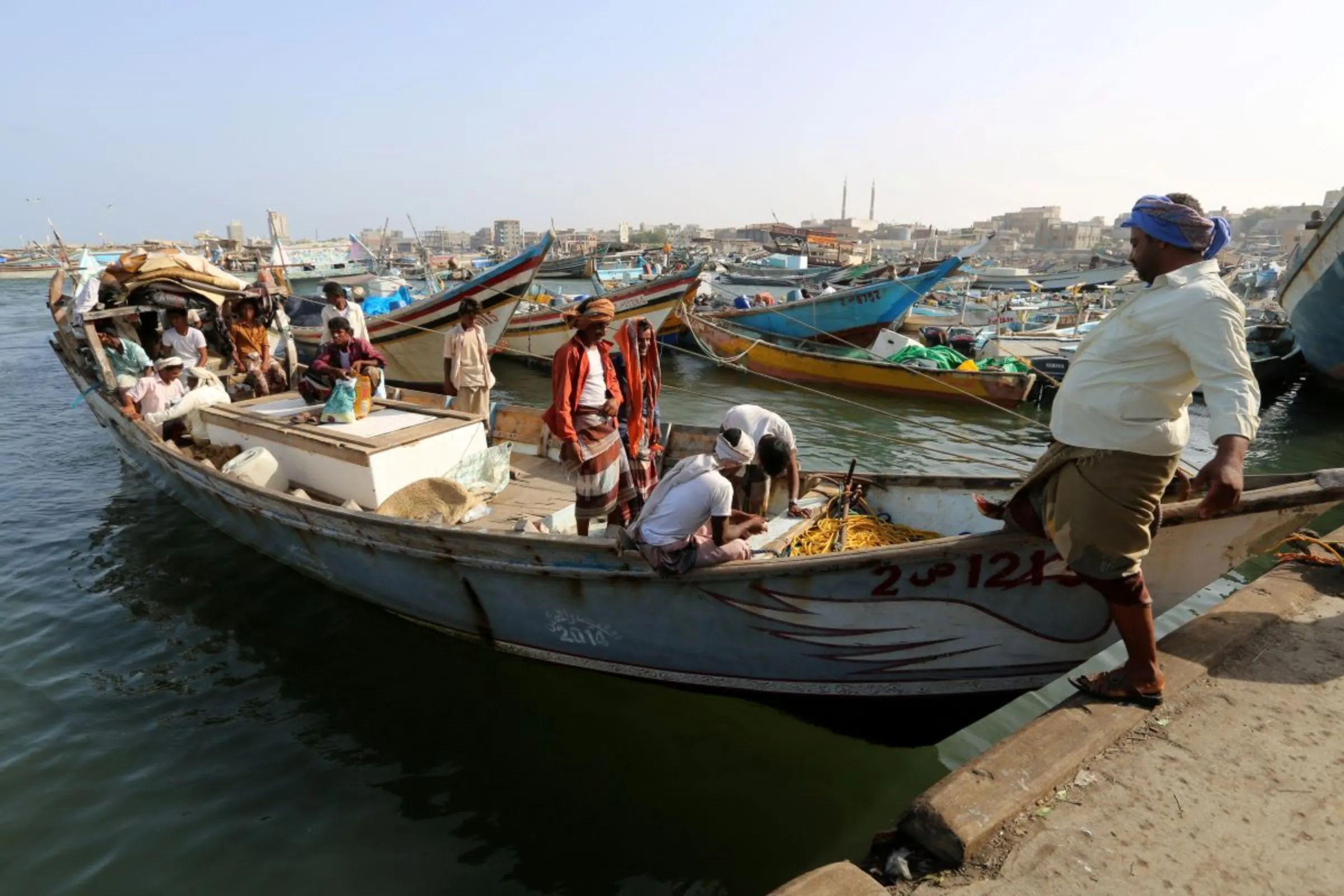 Fisherman steps into a boat at the fishing port of Hodeidah, Yemen April 17, 2019. REUTERS/Abduljabbar Zeyad
