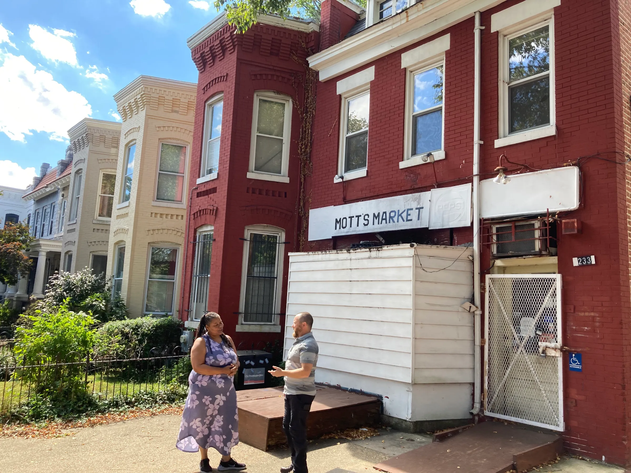 Christine Campbell and Michael Skinner talk in front of Mott’s Market in Washington D.C. on September 26, 2022