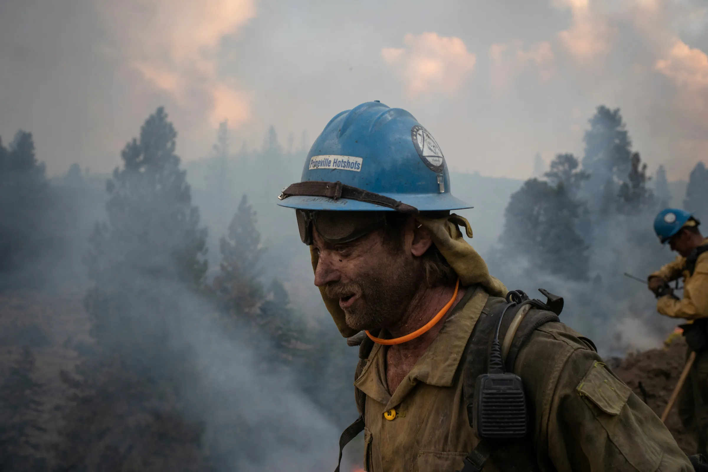 Kirk McDusky, a member of the Prineville Hotshot Crew, walks past smoke rising from the Brattain Fire in the Fremont National Forest in Paisley, Oregon, U.S., September 18, 2020