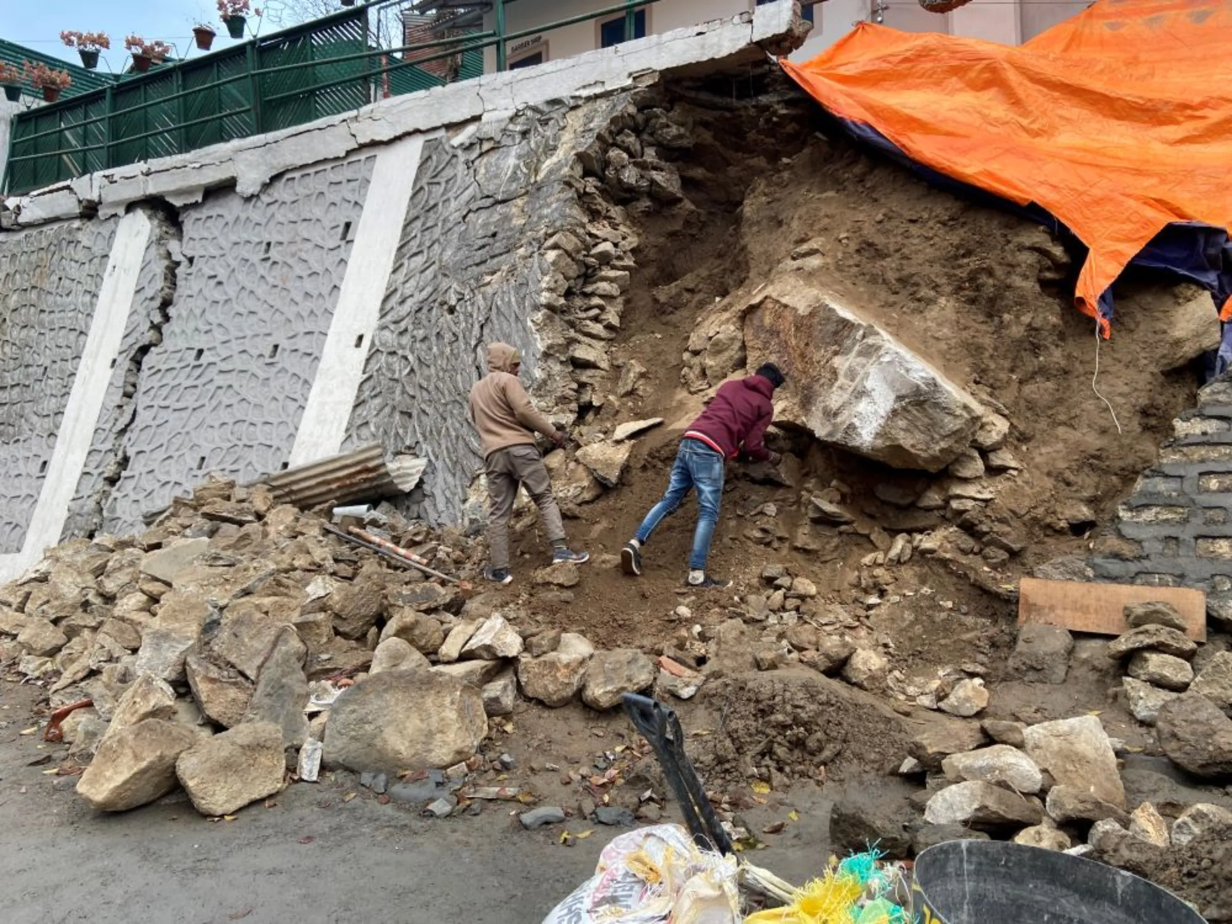 Workers remove debris from a massive crack in the wall of JP Colony in the Himalayan town of Joshimath, India, January 13, 2023
