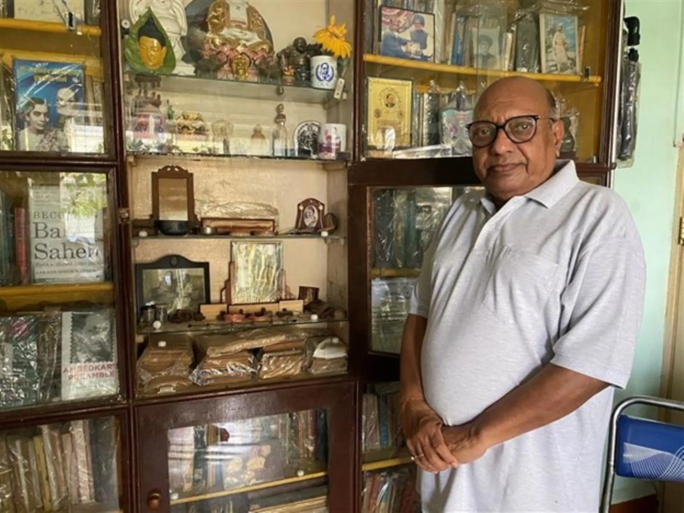 Dalit archivist Vijay Surwade, 69, poses in his apartment with his collection of dalit leader Babasaheb Ambedkar’s personal items in Kalyan on May 11, 2023. Thomson Reuters Foundation/Vidhi Doshi