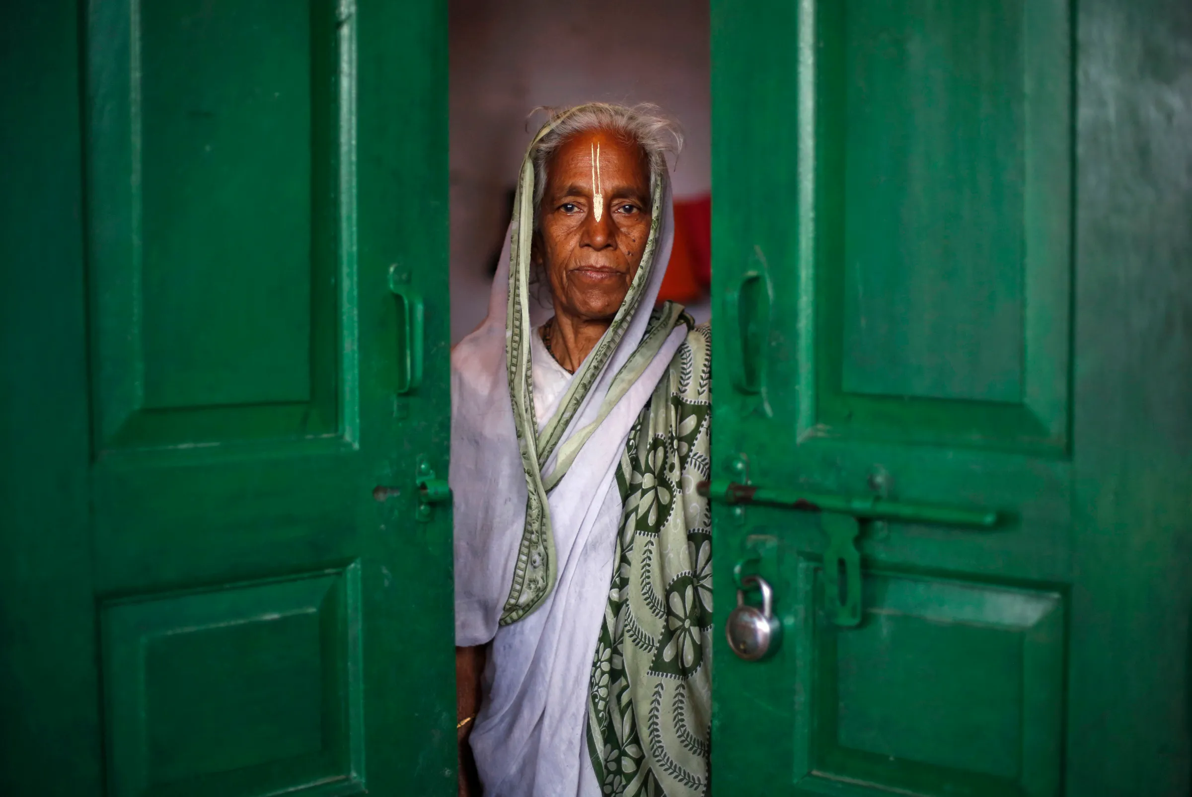 A widow poses for a picture inside her room at the Meera Sahavagini ashram in the pilgrimage town of Vrindavan in the northern Indian state of Uttar Pradesh March 6, 2013.
