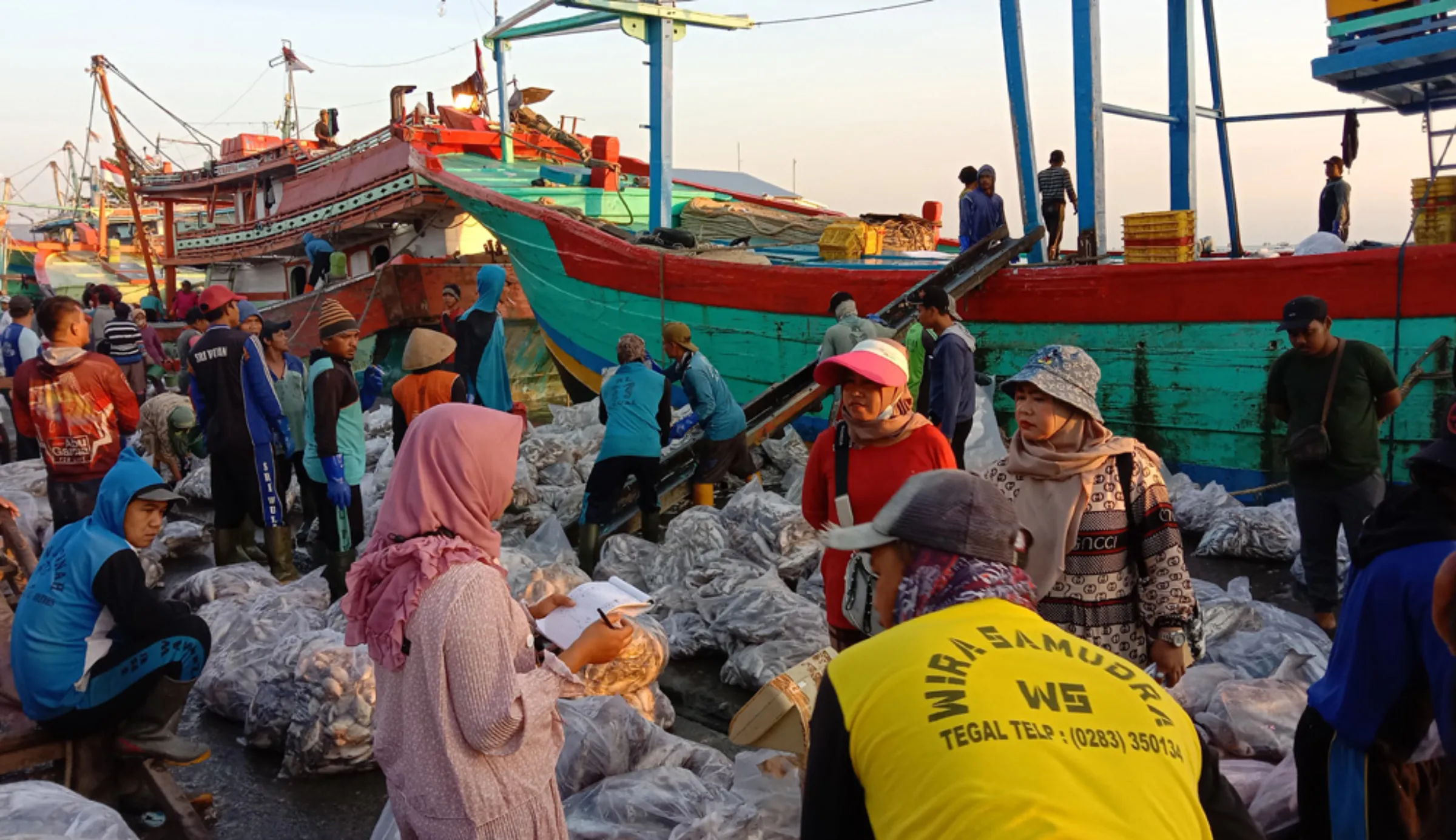 People load and unload fish at the Tegalsari port in Central Java, Indonesia, July 2, 2022