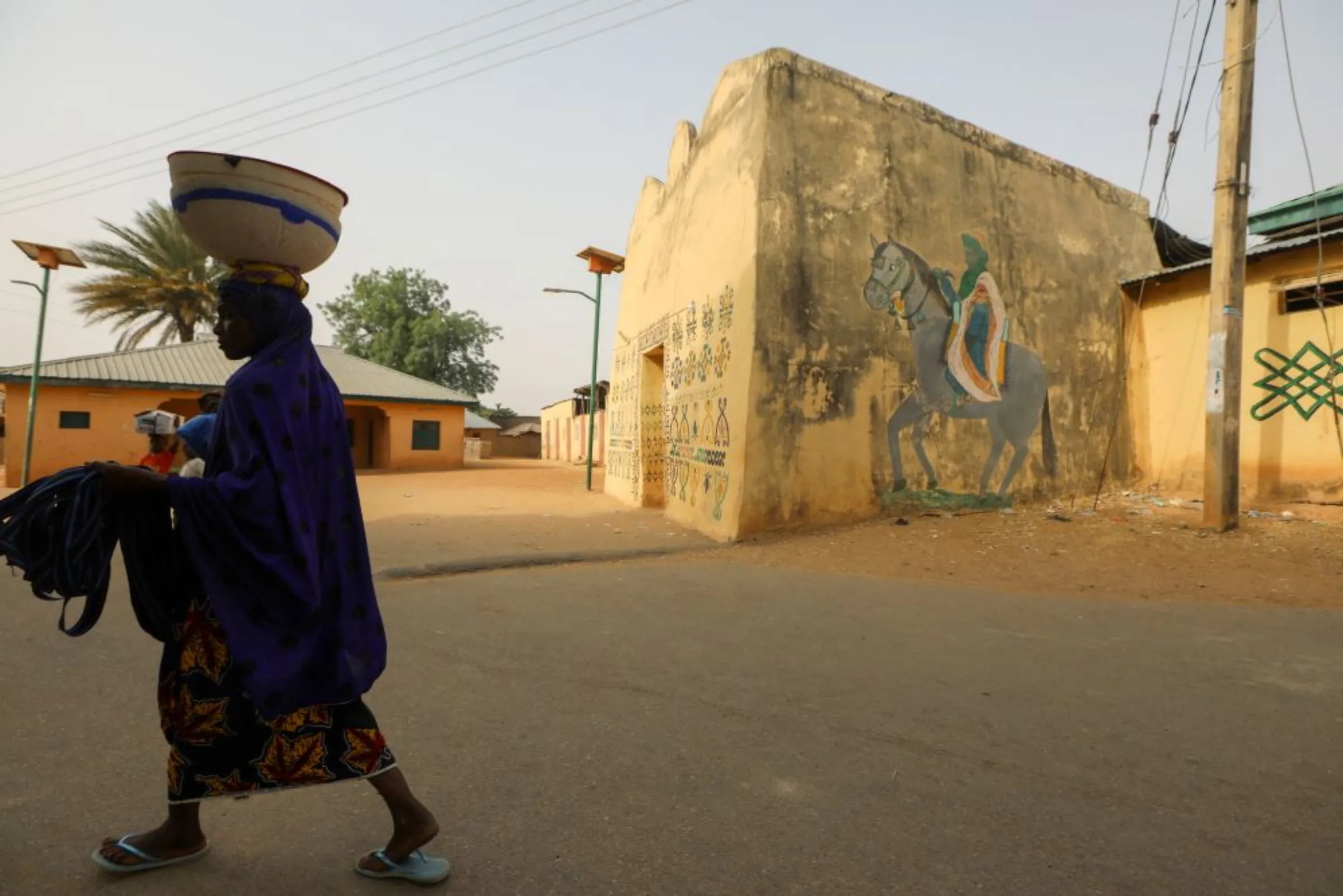 A woman walks past the palace of the Emir of Anka in Zamfara, Nigeria February 28, 2021