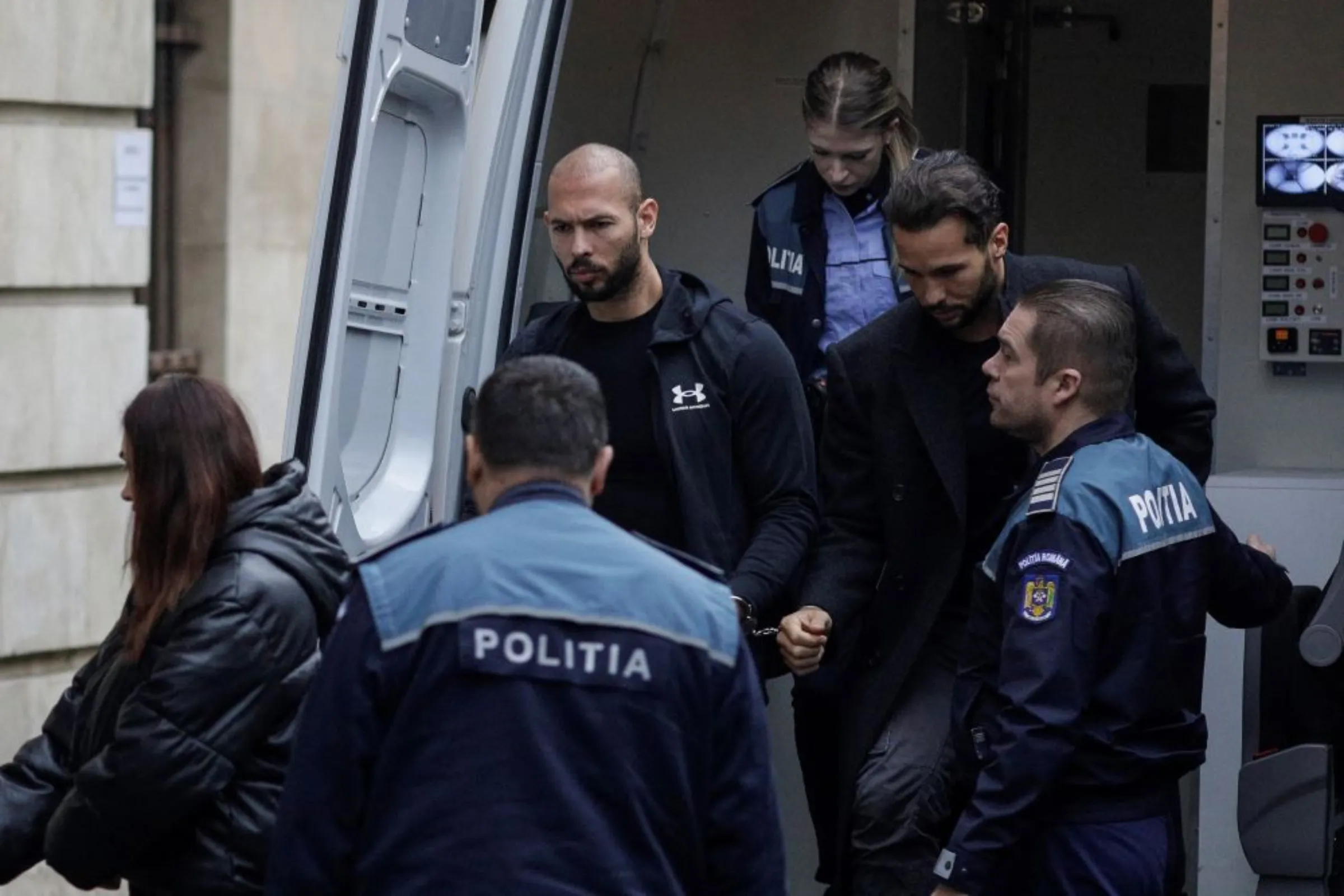 Andrew Tate and his brother Tristan are escorted by police officers outside the headquarters of the Bucharest Court of Appeal, in Bucharest, Romania, January 10, 2023. Inquam Photos/Octav Ganea via REUTERS