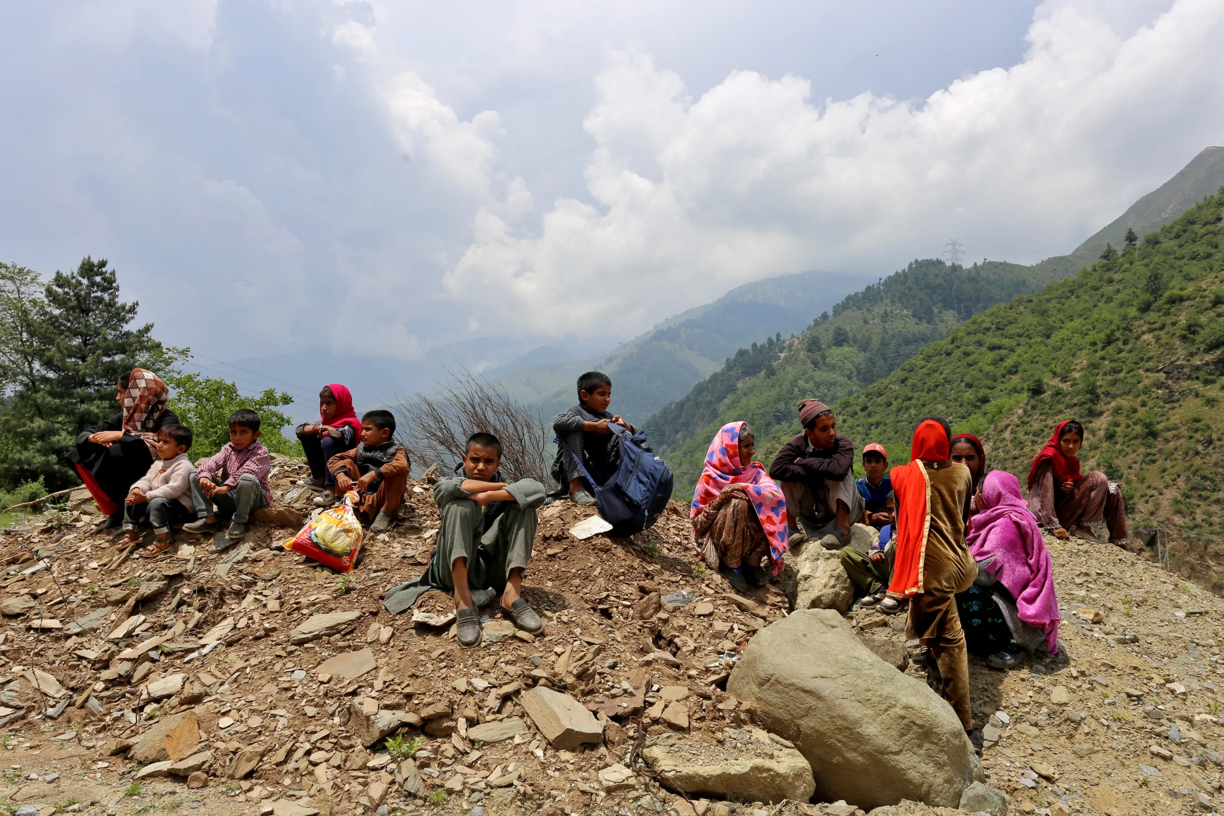 People who were evacuated from their homes near the Line of Control (LoC) between India and Pakistan following cross-border shelling, wait as authorities stopped them returning to their villages until the areas are cleared of unexploded ordnance, after the ceasefire between the two countries, in Gantamulla in Indian Kashmir's Baramulla district May 11, 2025. REUTERS/Stringer