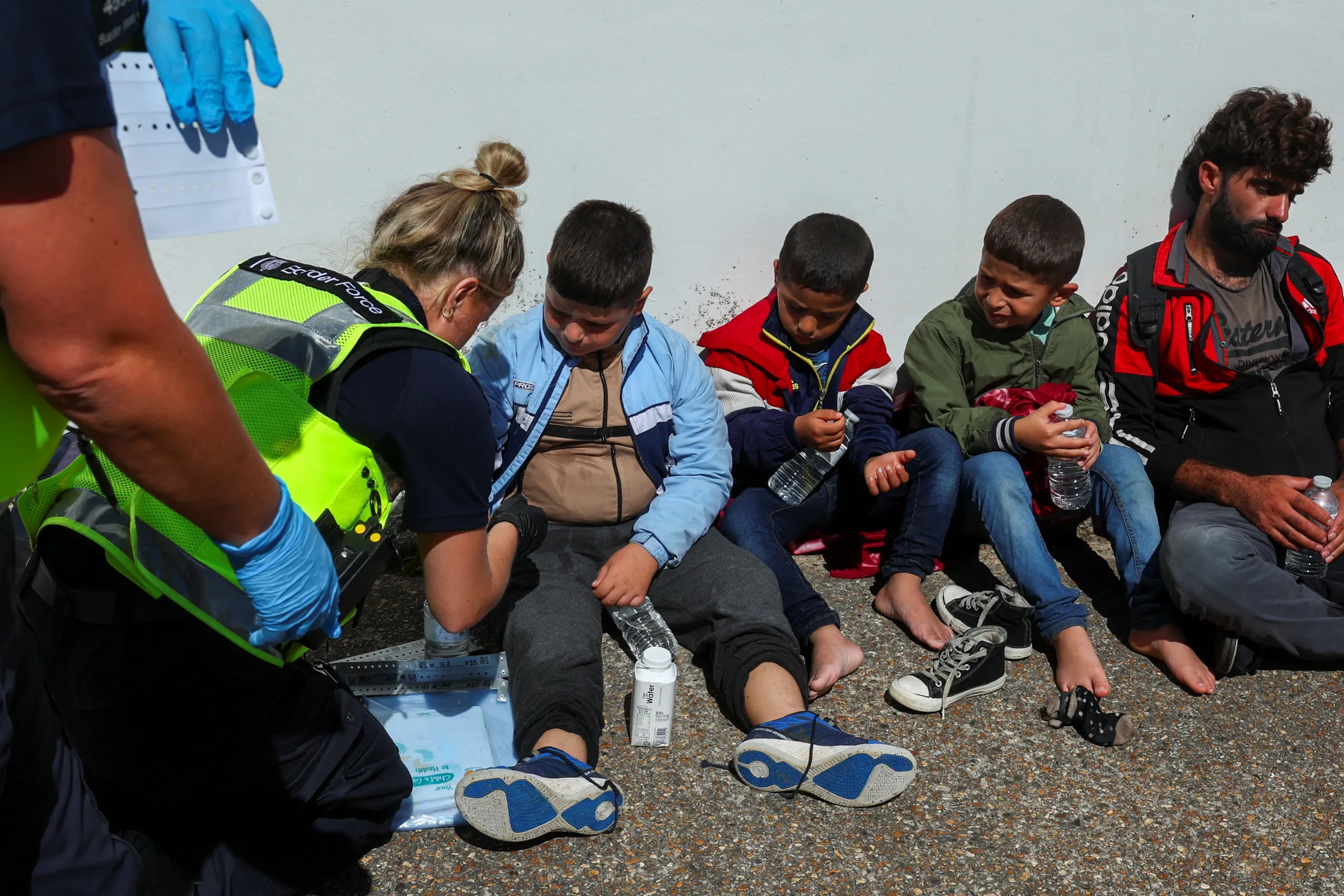 A member of the Border Force helps children, who are believed to be migrants, as they arrive in Dungeness, Britain, August 16, 2023. REUTERS/Toby Melville