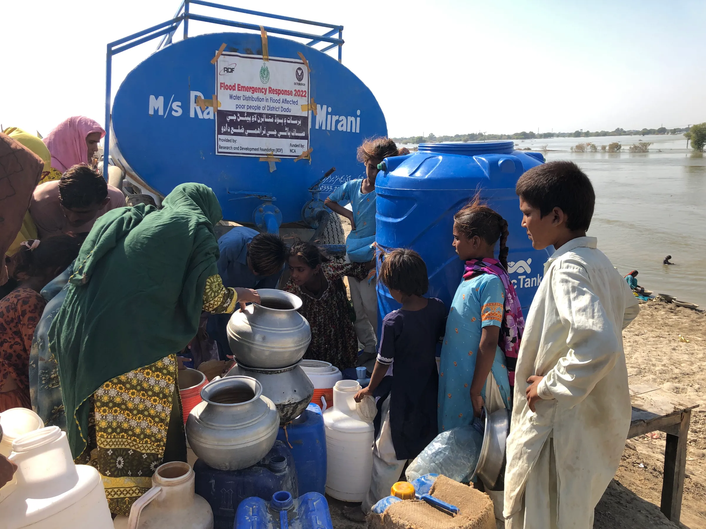 Women and children displaced from the flooded village of Ibrahim Chandio, who are now living on the embankment of Main Nara Valley Drain, in Sindh province, Pakistan, October 14, 2022. Thomson Reuters Foundation/Zofeen Ebrahim