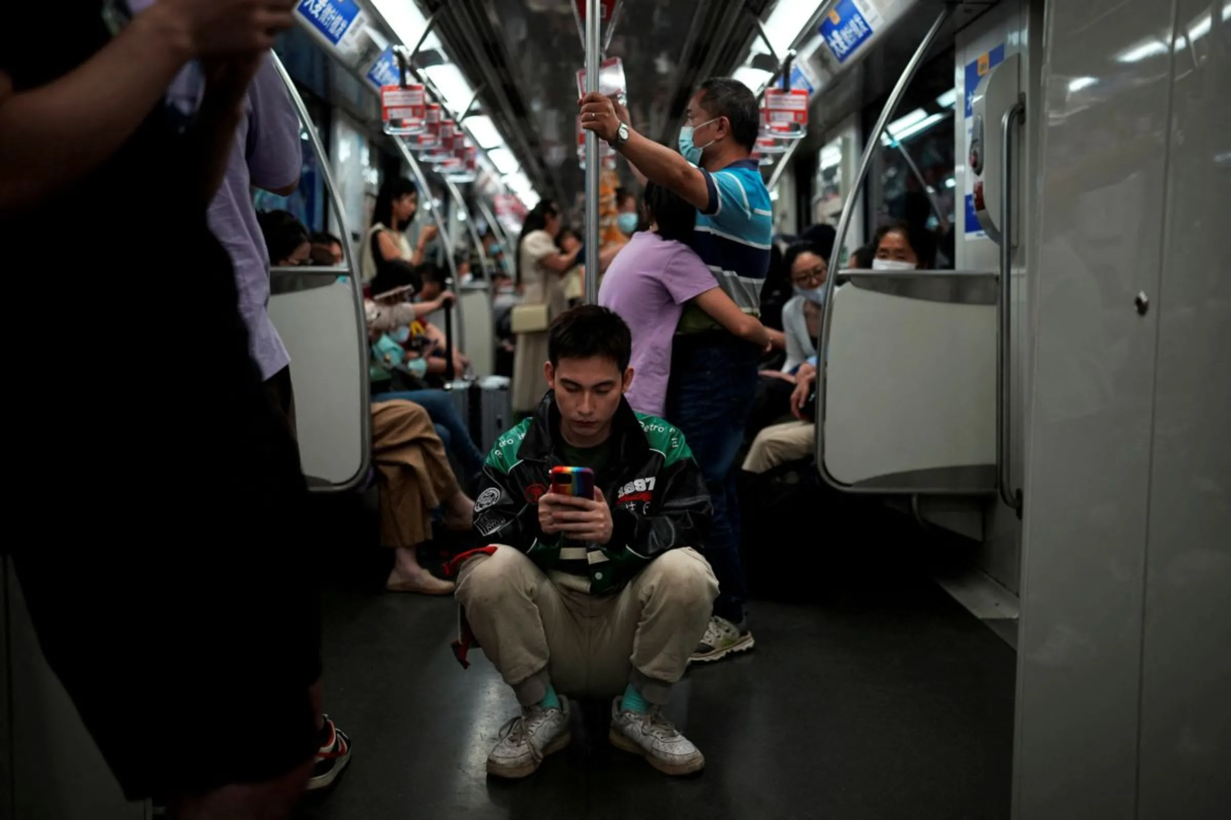 A man checks his phone on a subway train in Shanghai, China, June 3, 2023