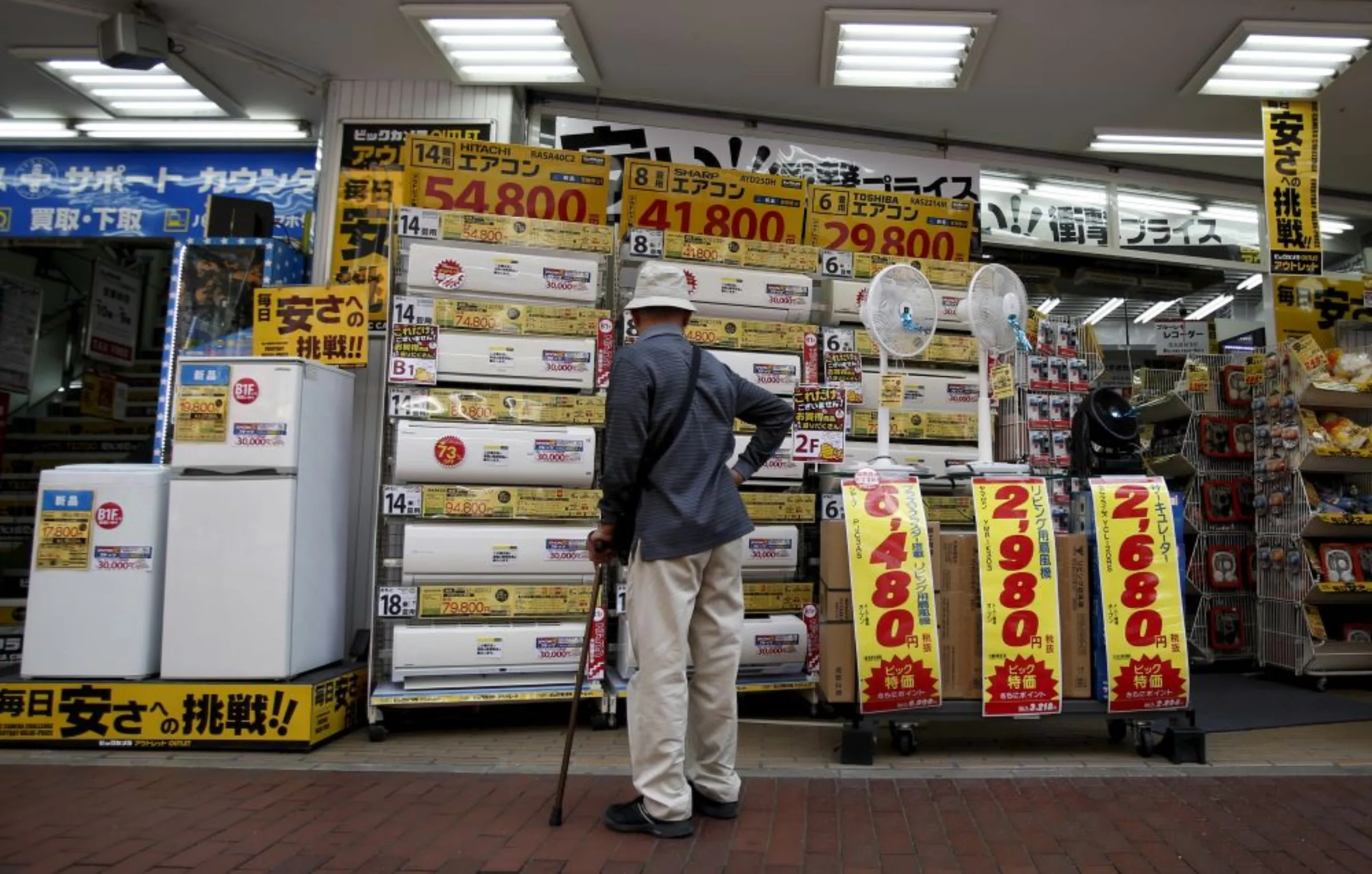 A man looks at air conditioners outside a discount electronics store at a shopping district in Tokyo, Japan, April 28, 2015. REUTERS/Yuya Shino