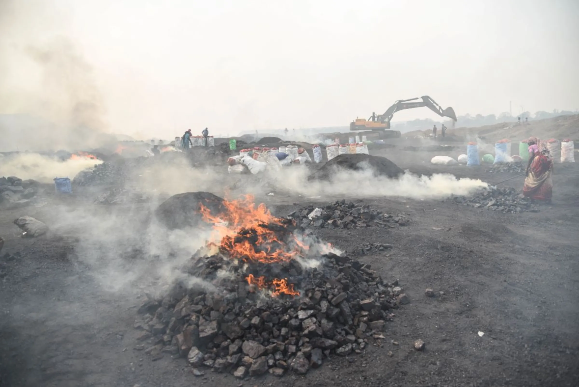 Illegal coal scavengers burn coal in a mining area at Jharia coalfield, India, November 11, 2022. Thomson Reuters Foundation/Tanmoy Bhaduri