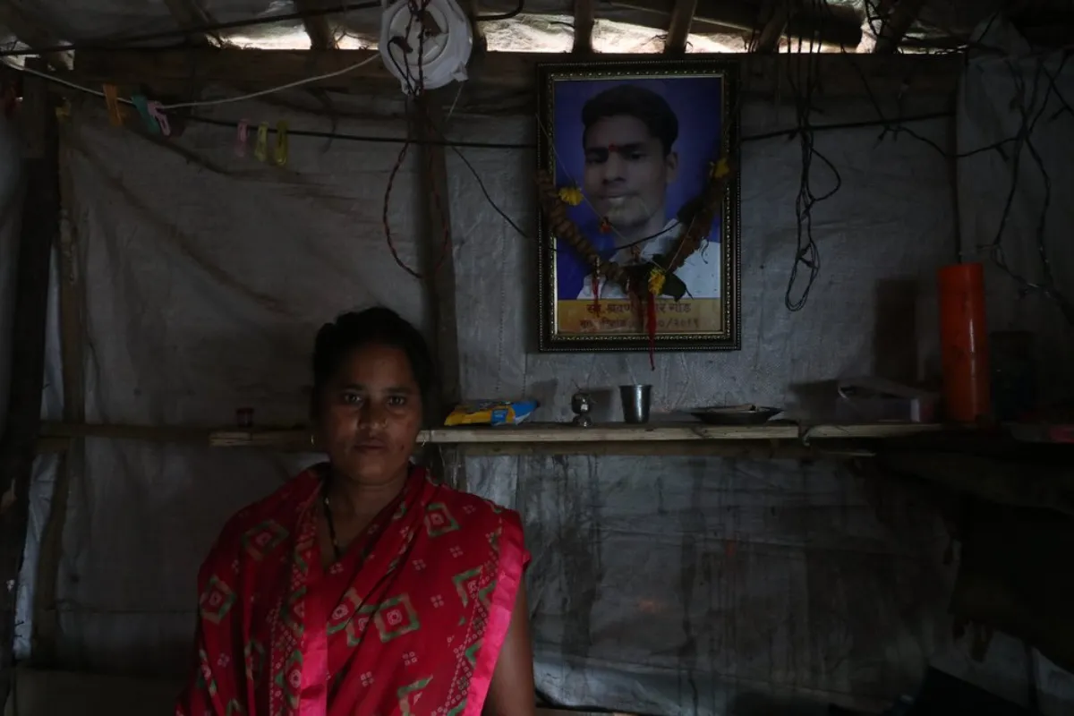 Munni Gaud stands next to a picture of her late son, after he was died when a water storage retaining wall collapsed in 2019 during heavy rains in Mumbai, India, September 6, 2021
