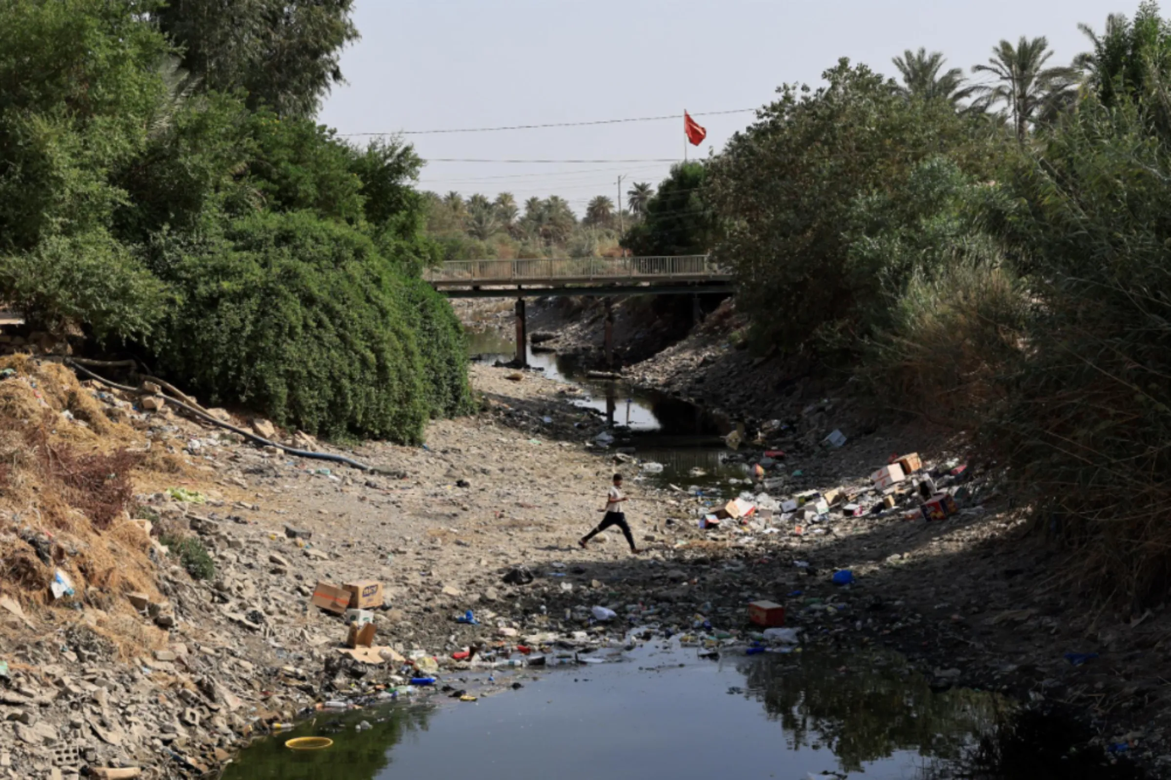 A boy walks in a dry river in al-Meshkhab district of Najaf, Iraq, October 12, 2022