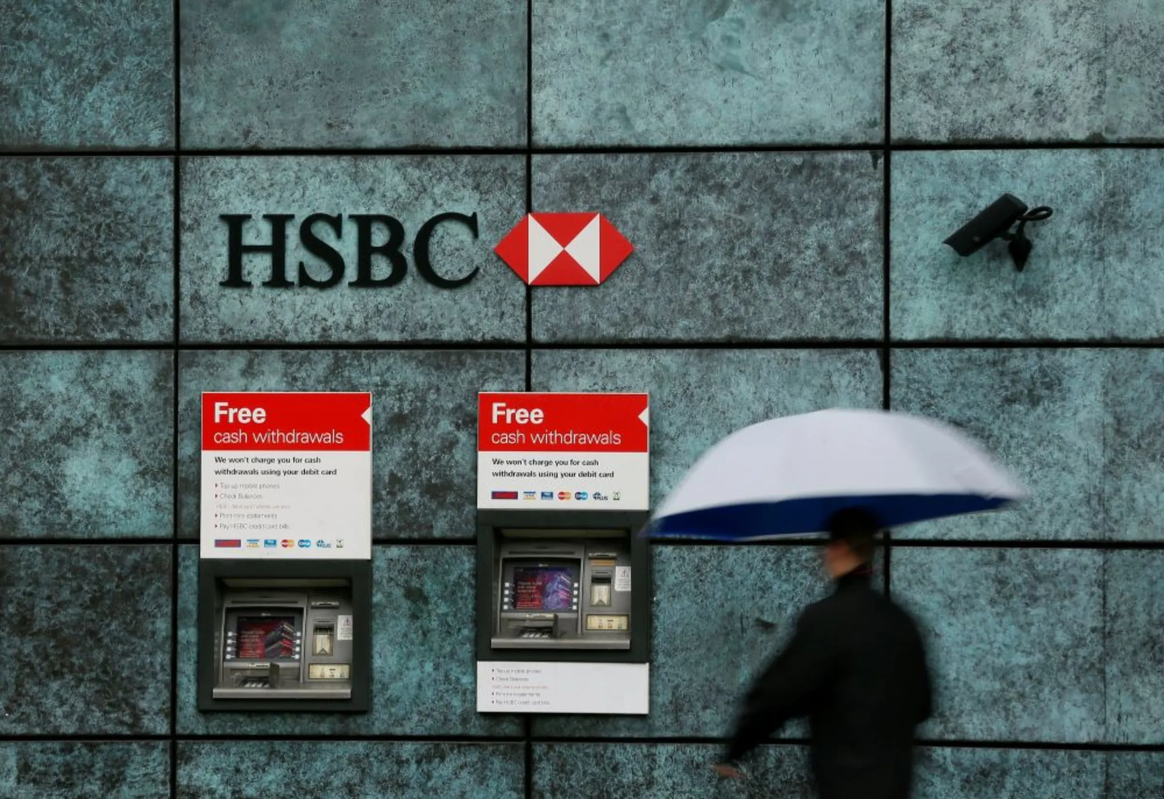 A man walks past a HSBC bank branch in the City of London, Britain November 12, 2014