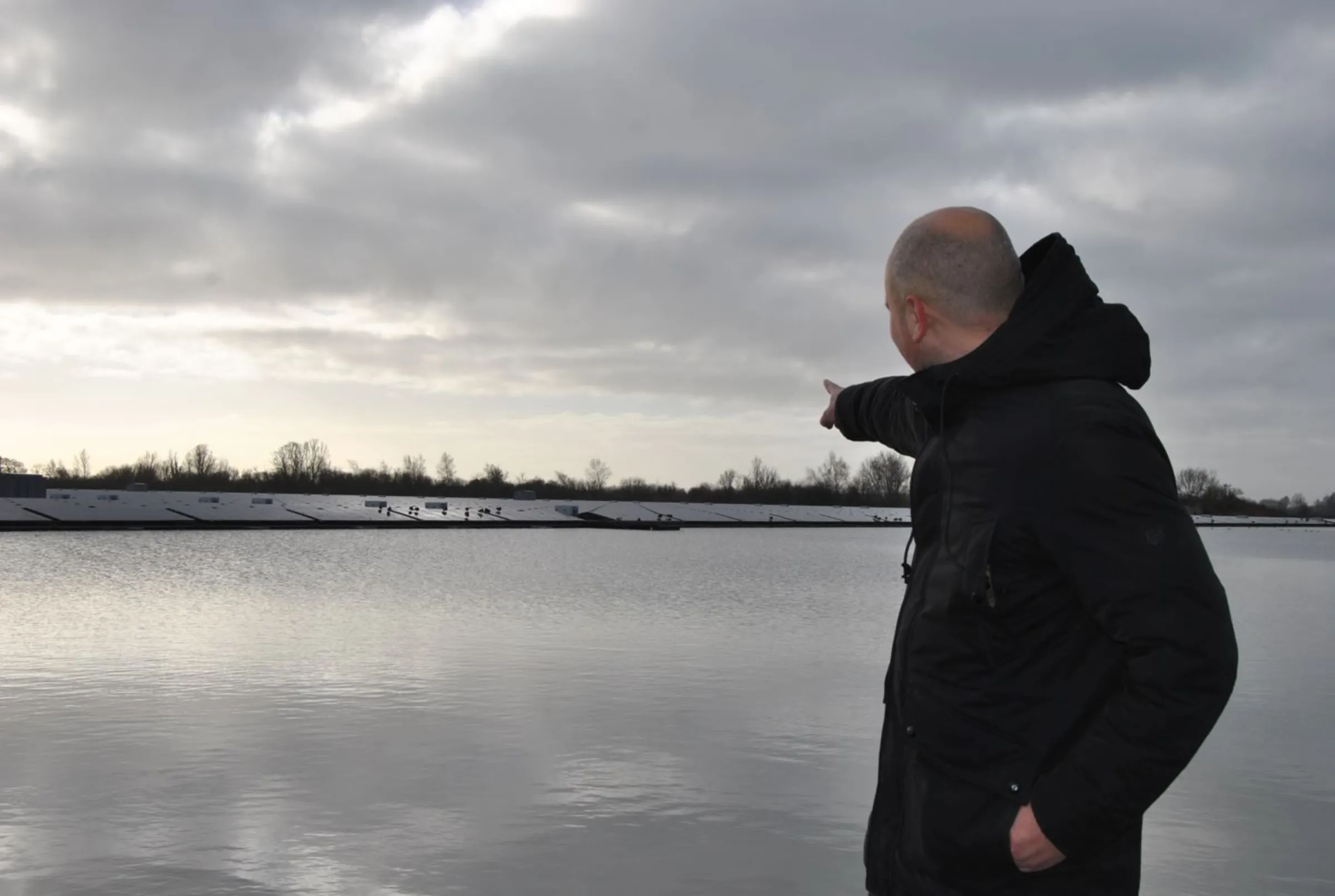 GroenLeven's Maarten de Groot points at the company's Nij Beets floating solar farm at Nij Beets, the Netherlands, January 26, 2023. Thomson Reuters Foundation/Karolin Schaps