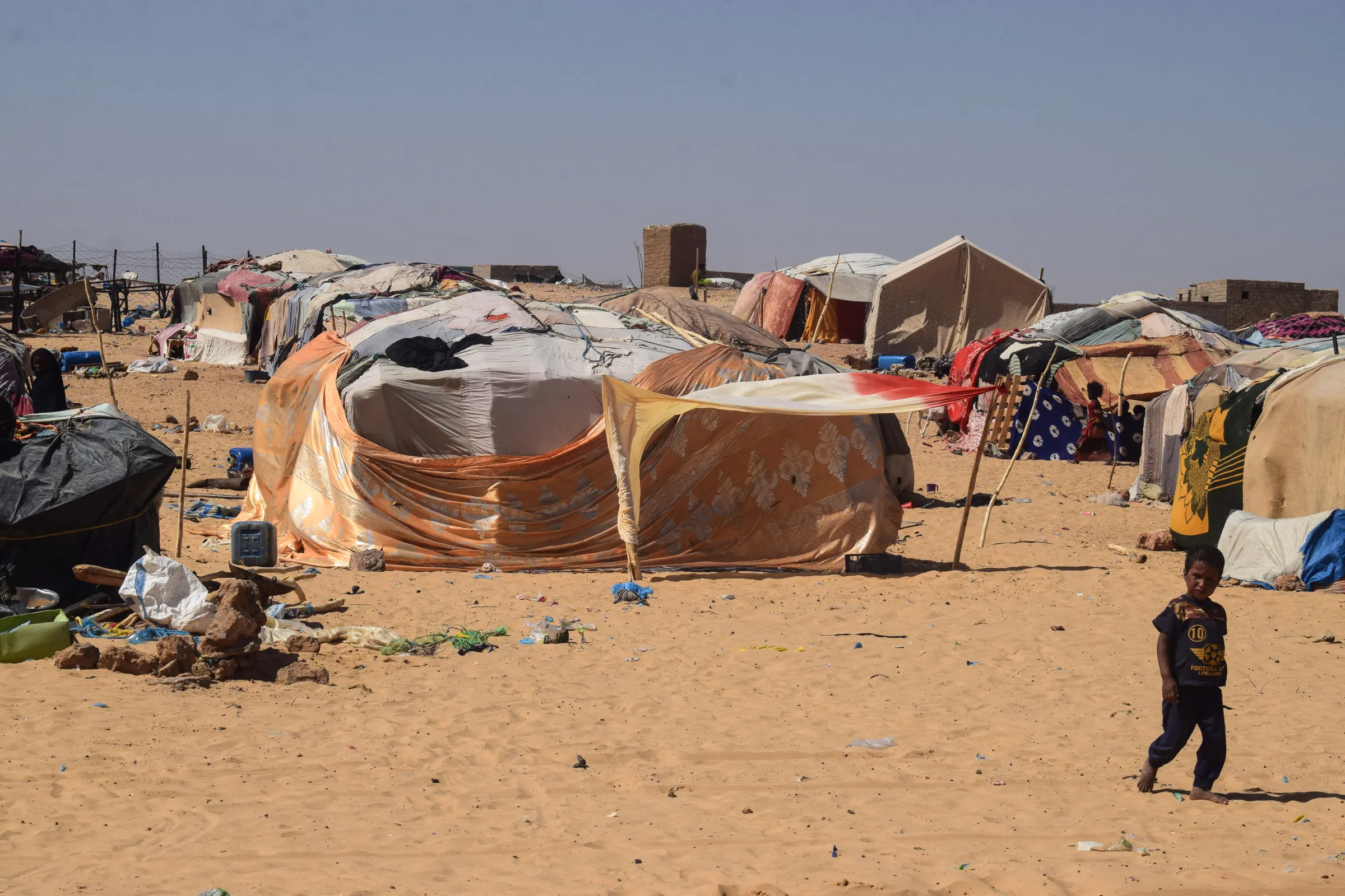 A displaced boy walks beside makeshift shelters at the Internally Displaced People's (IDP) camp in Tinzaouaten, northern Mali November 7, 2024. REUTERS/ Abdolah Ag Mohamed