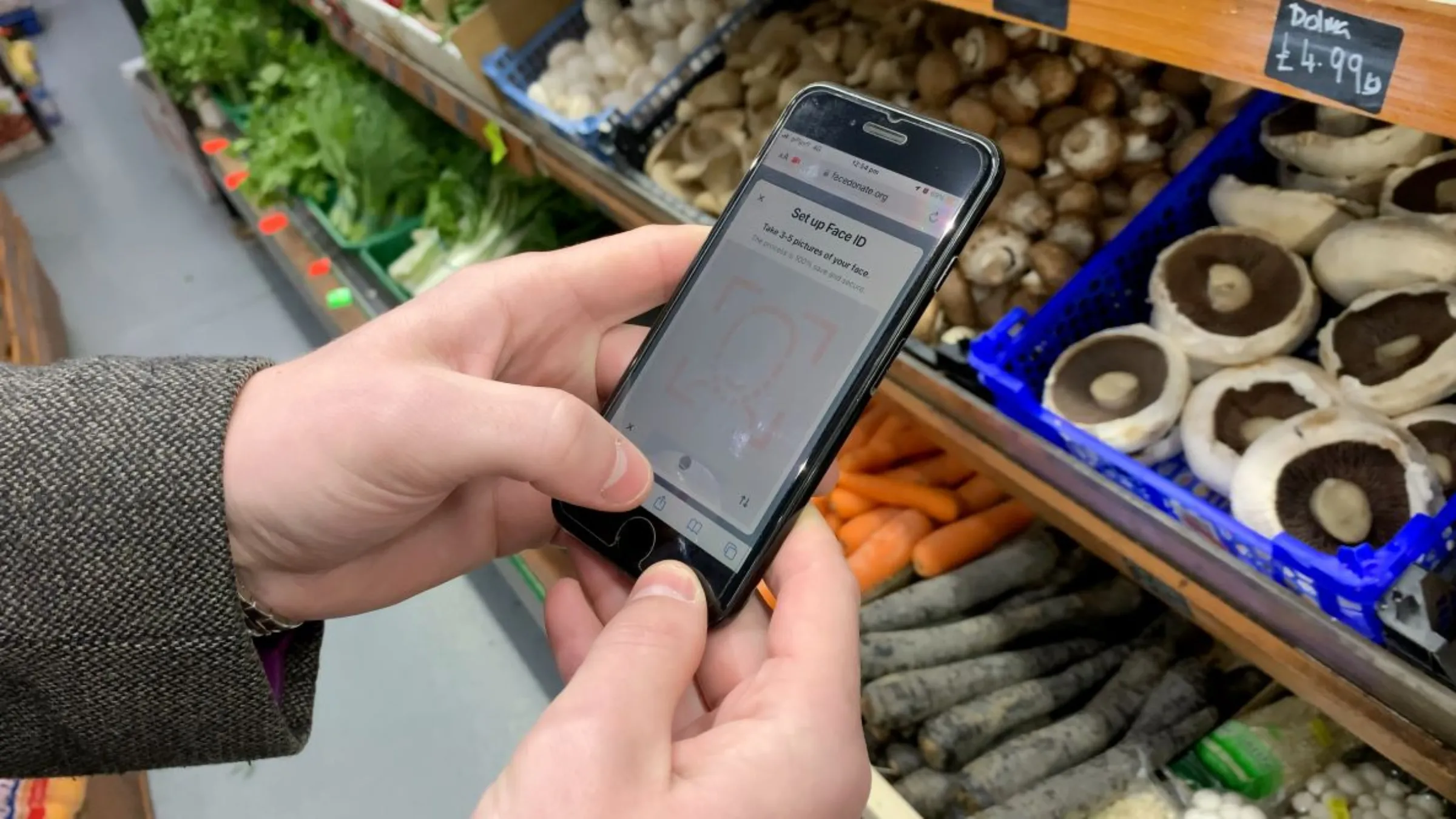 A user in a local grocery store uses FaceDonate, a donations app that lets users receive and pay for essential items with face scans, in east London, Britain on April 24, 2023