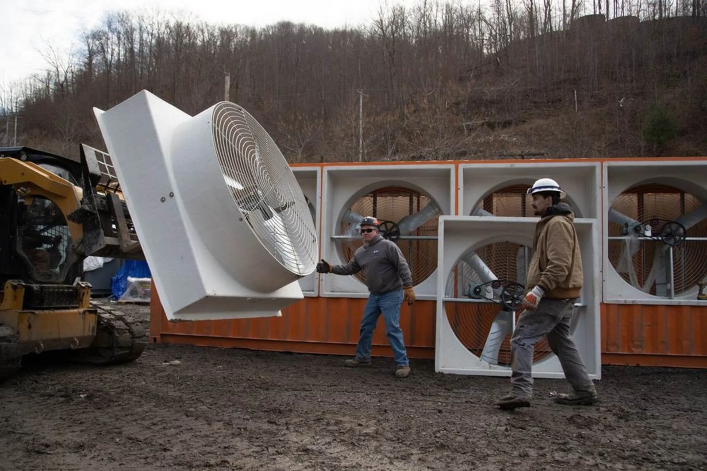 Construction workers move fans on a bitcoin mining operation in Belfry, Kentucky, January 24, 2022