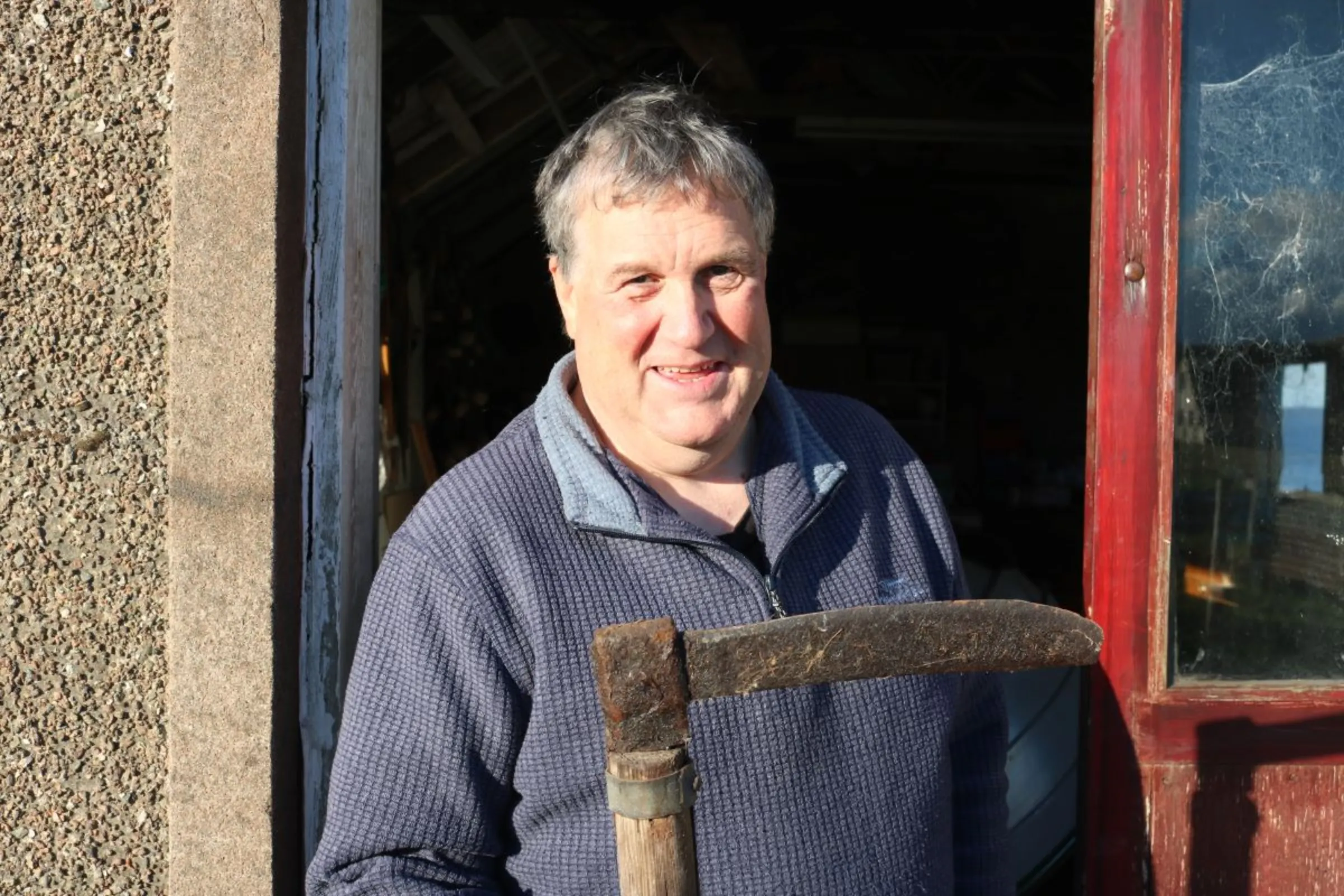 Douglas Irvine from Shetland Islands Council shows an old ripper, a turf-cutting tool which his ancestors relied on to cut and dry peat for energy, on Mainland, Shetland, Scotland, October 31, 2023. Thomson Reuters Foundation/Jack Graham