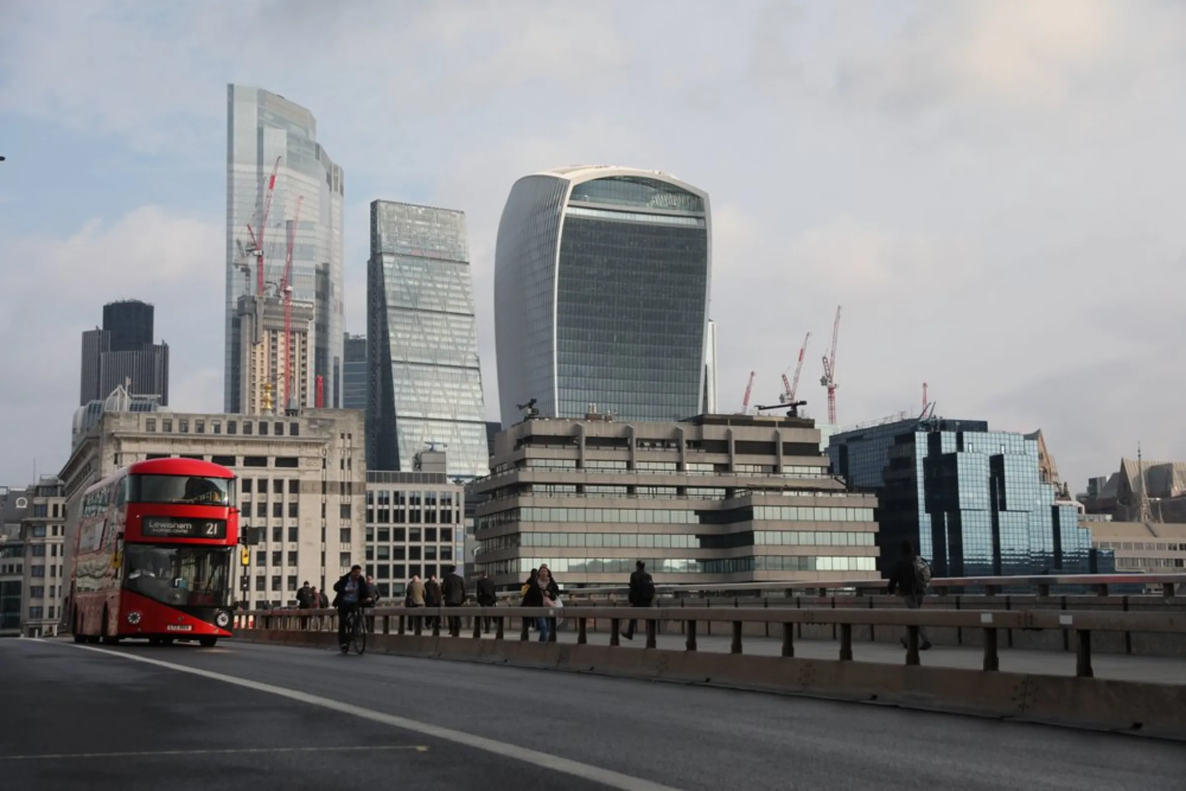 A Routemaster double-decker bus travels across London Bridge in view of London’s financial district on October 19, 2021