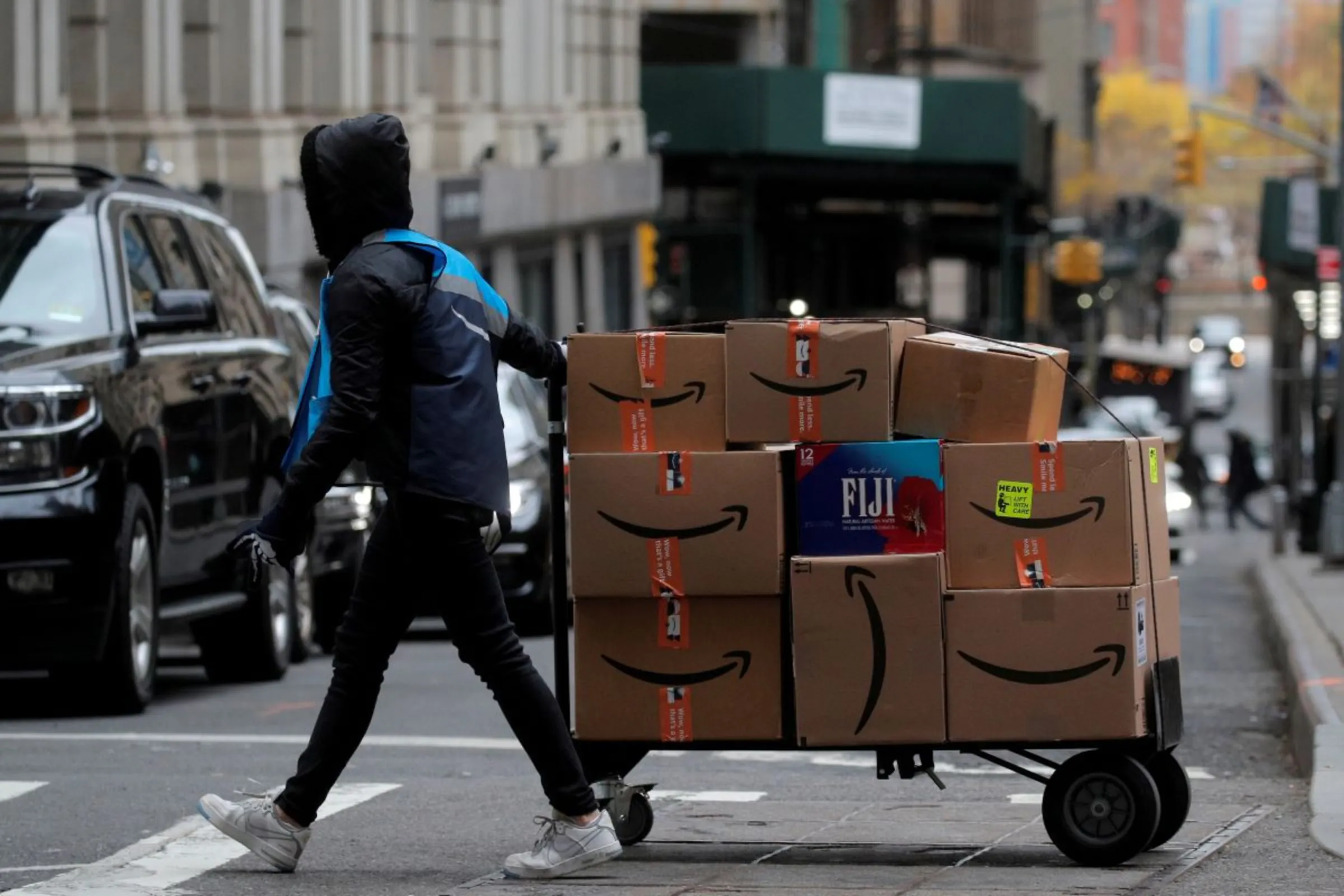 An Amazon delivery worker pulls a cart full of boxes for delivery on Cyber-Monday in New York City, U.S., November 29, 2021. REUTERS/Brendan McDermid